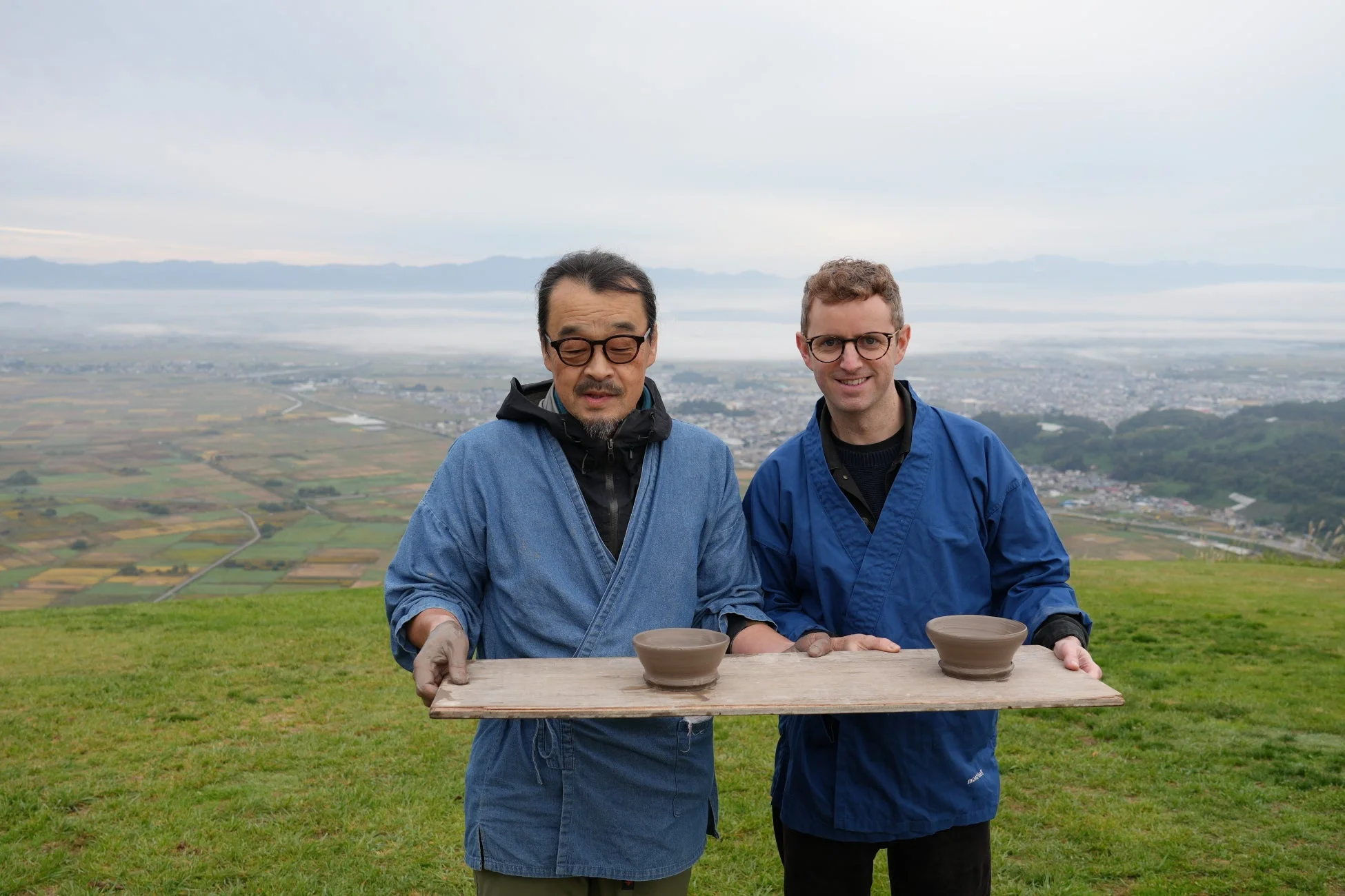 陶器の碗を持つ男性二人