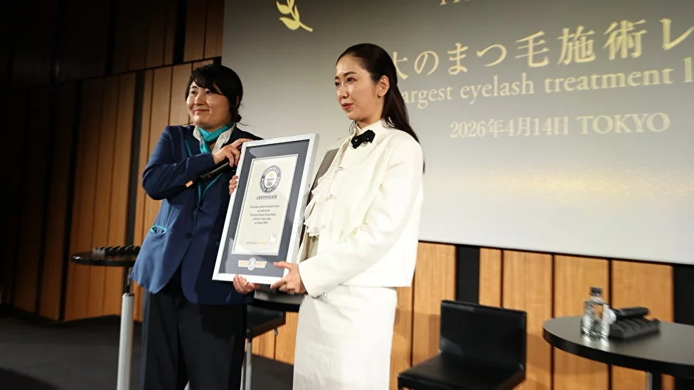 ステージ上で、2人の女性がギネス世界記録の認定証を掲げている画像