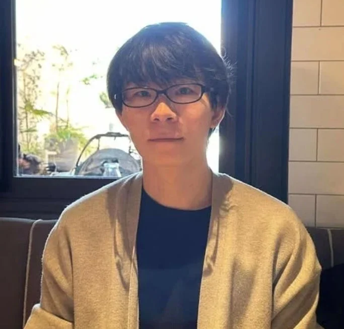 眼鏡をかけたアジア人男性がカメラを見つめているポートレート