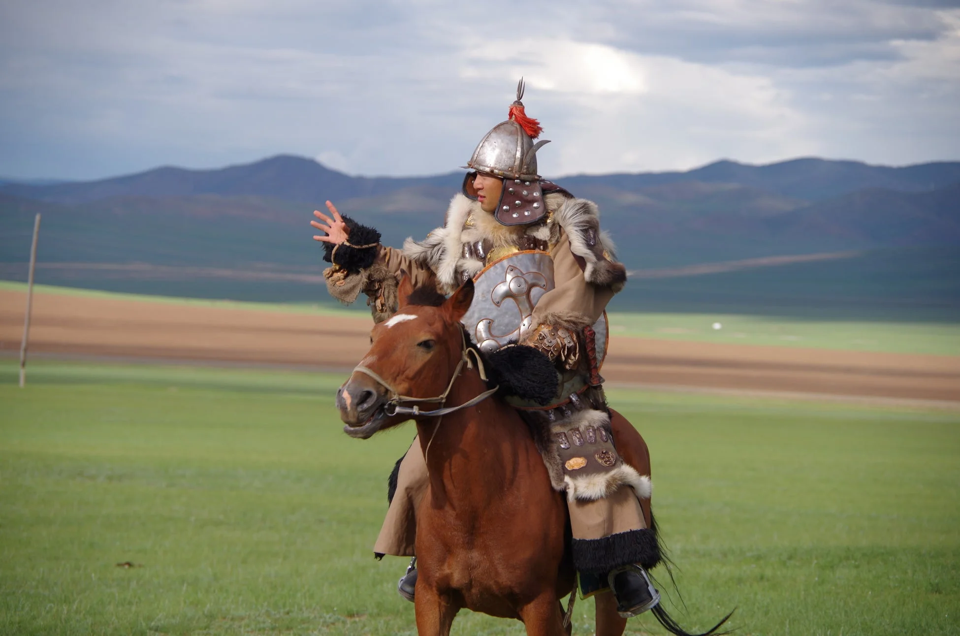 モンゴルの伝統衣装をまとい馬に乗る人物