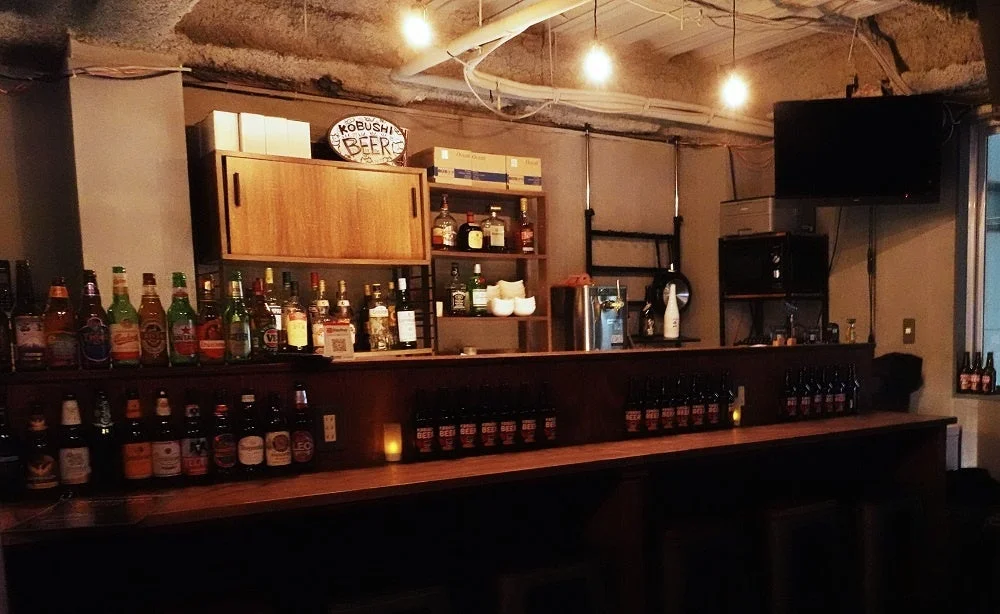 様々な種類のビールや洋酒が並べられたバーカウンターの様子