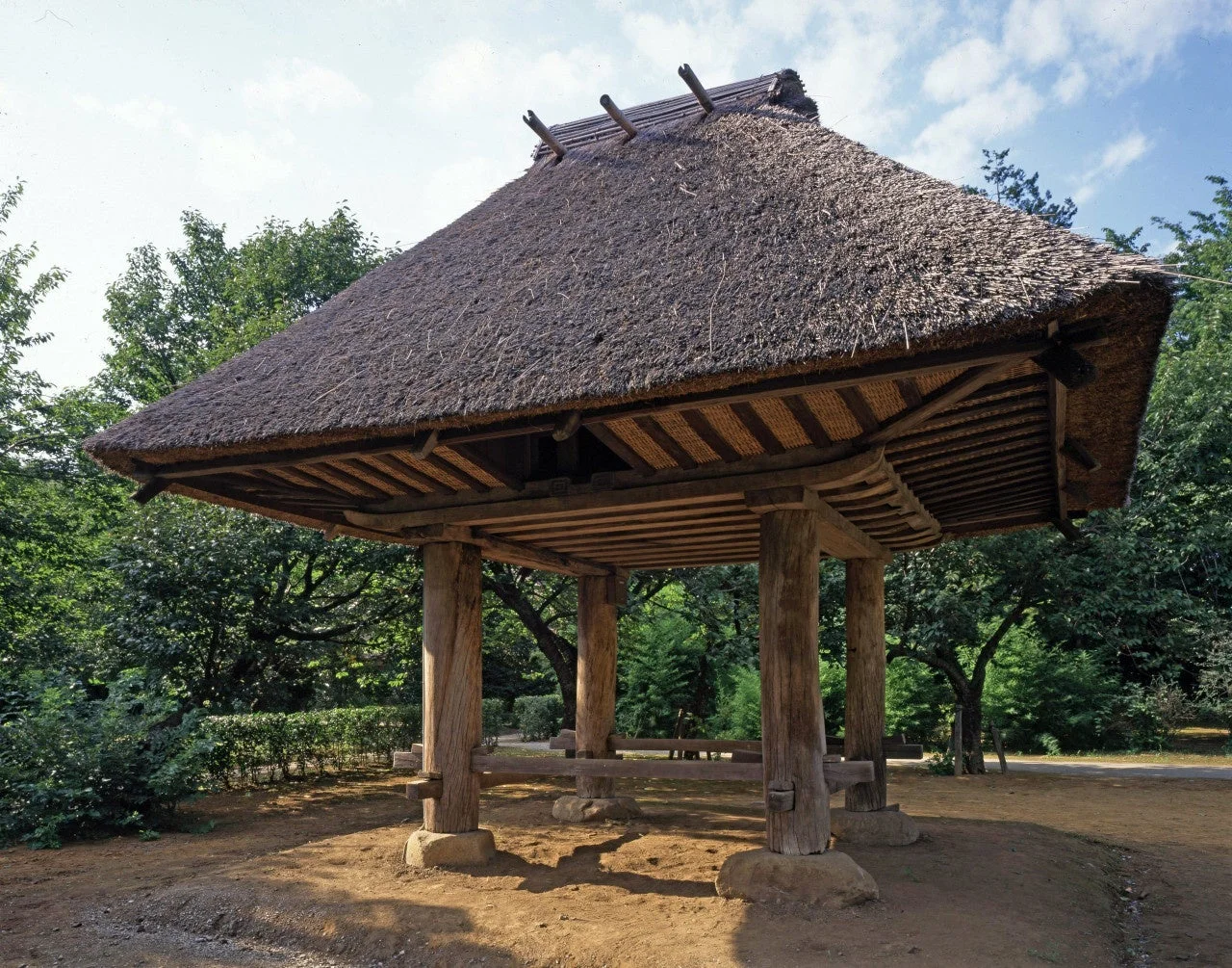 豊かな緑に囲まれた茅葺き屋根の東屋