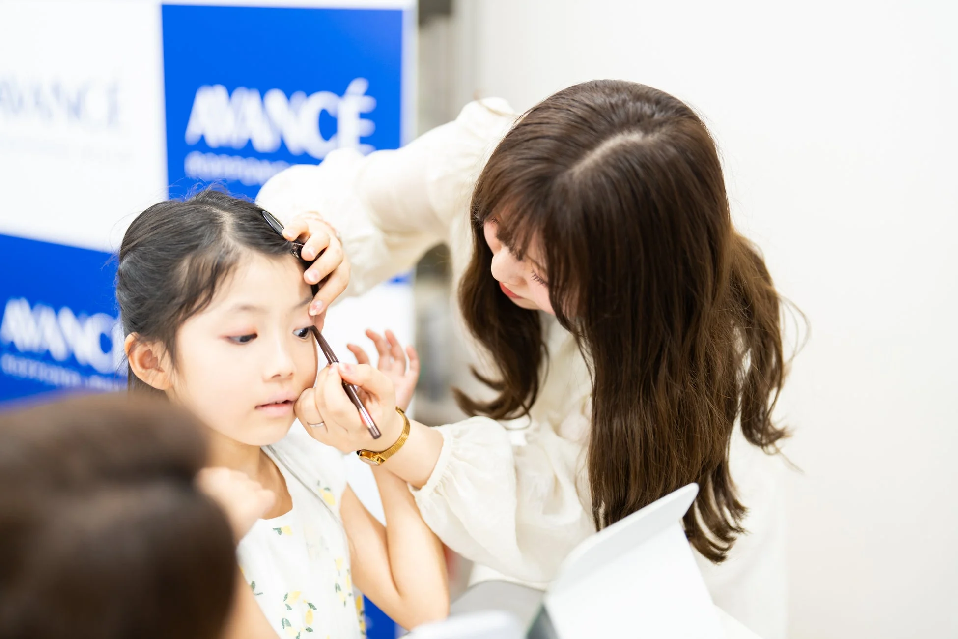 子どもにアイライナーを施す様子
