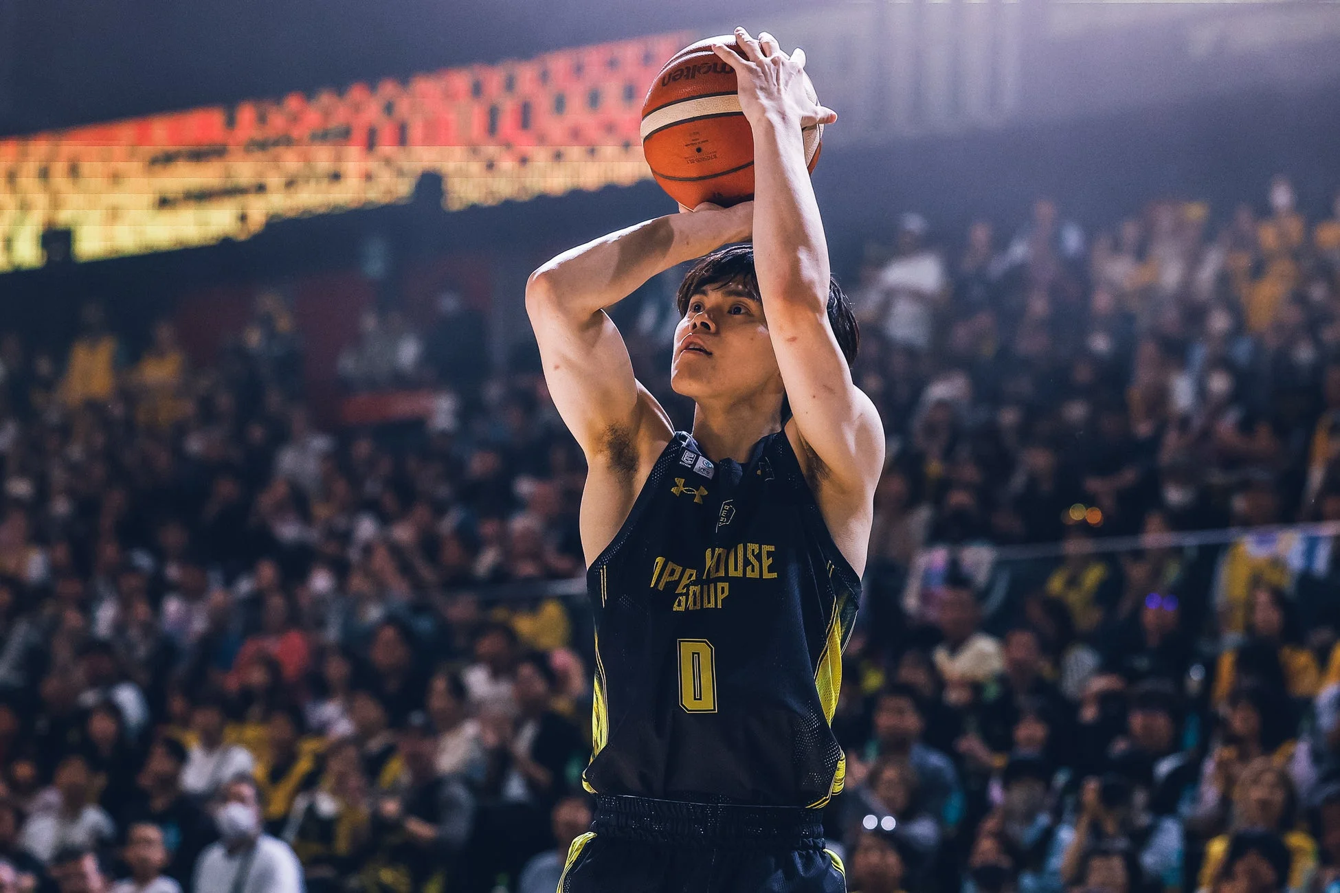 バスケットボール選手が試合中にシュートを放とうとしている瞬間