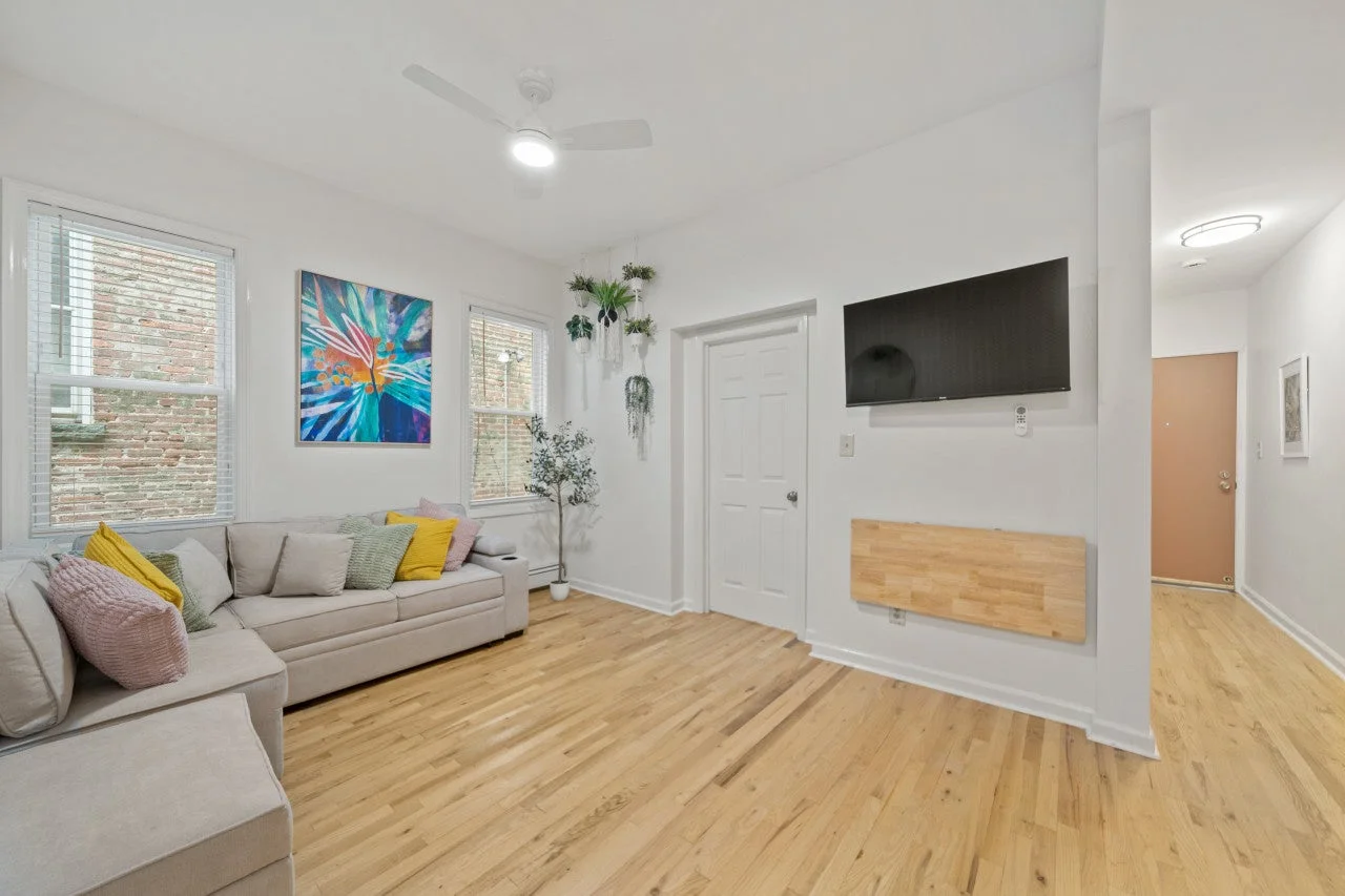 明るい白壁と木製のフローリングが特徴のモダンなリビングルーム