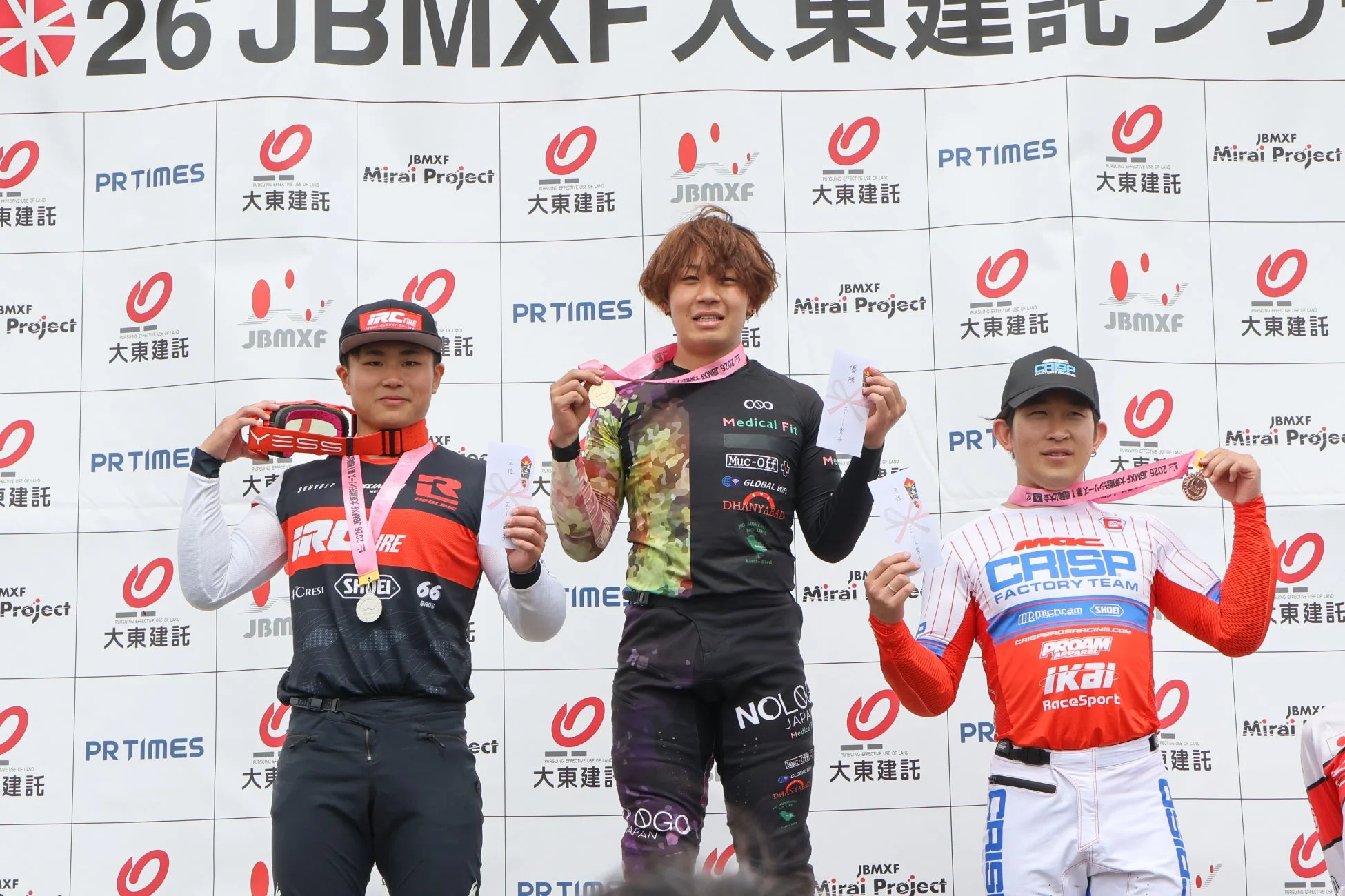 JBMXFのレースで表彰台に立つ3人の男性アスリート