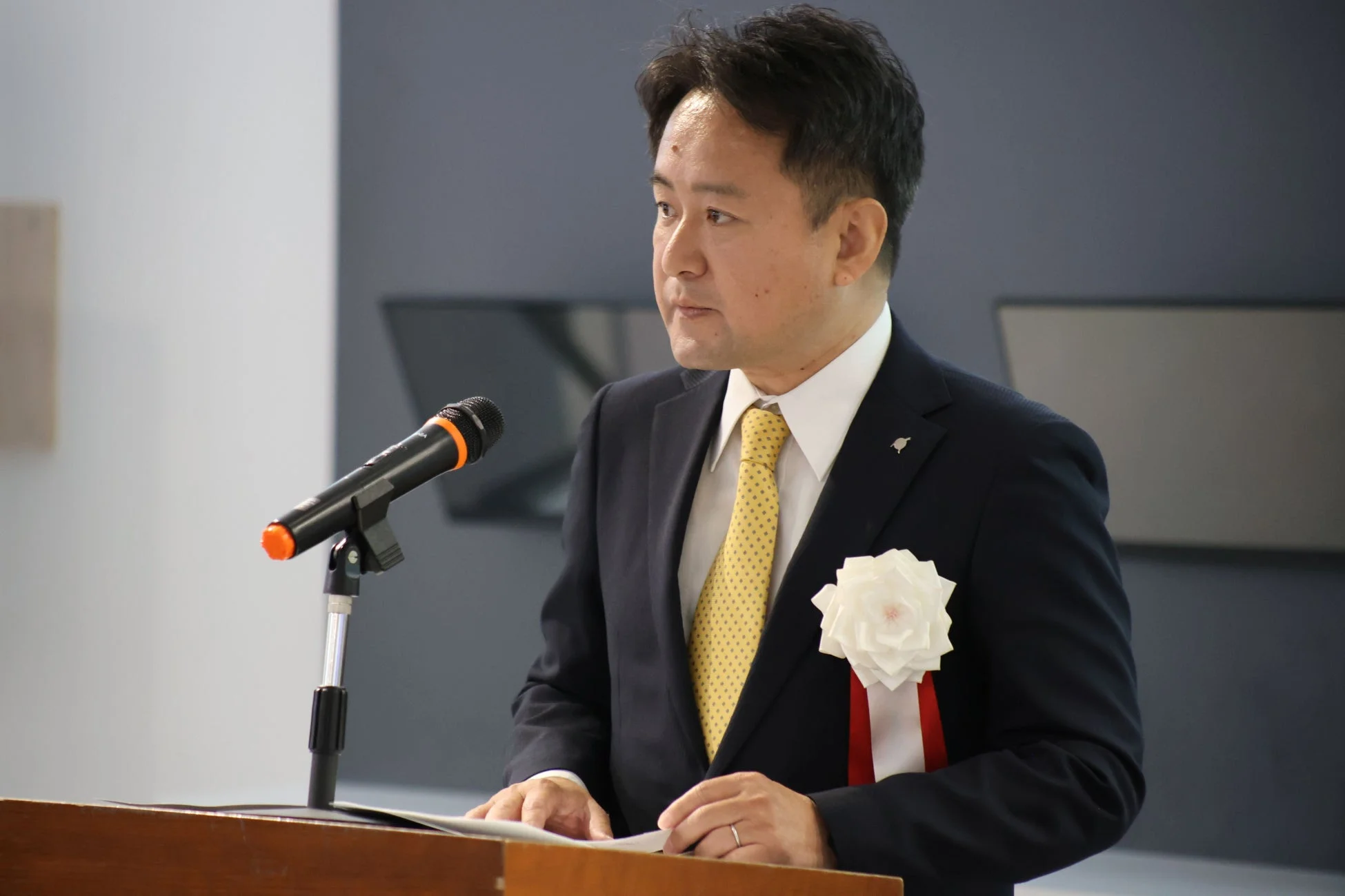壇上でスピーチをする学院長