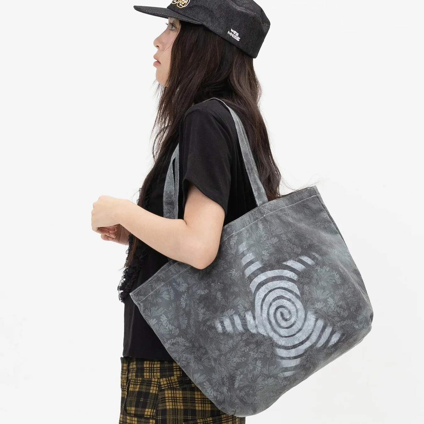 キャップとトートバッグの女性
