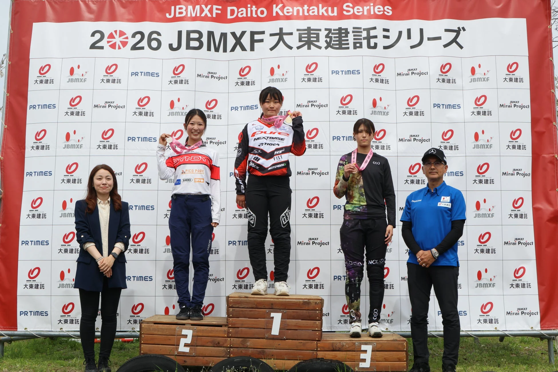JBMXF大東建託シリーズの表彰式の様子。メダルを首にかけた3人の女性BMX選手が表彰台に立ち、笑顔を見せている