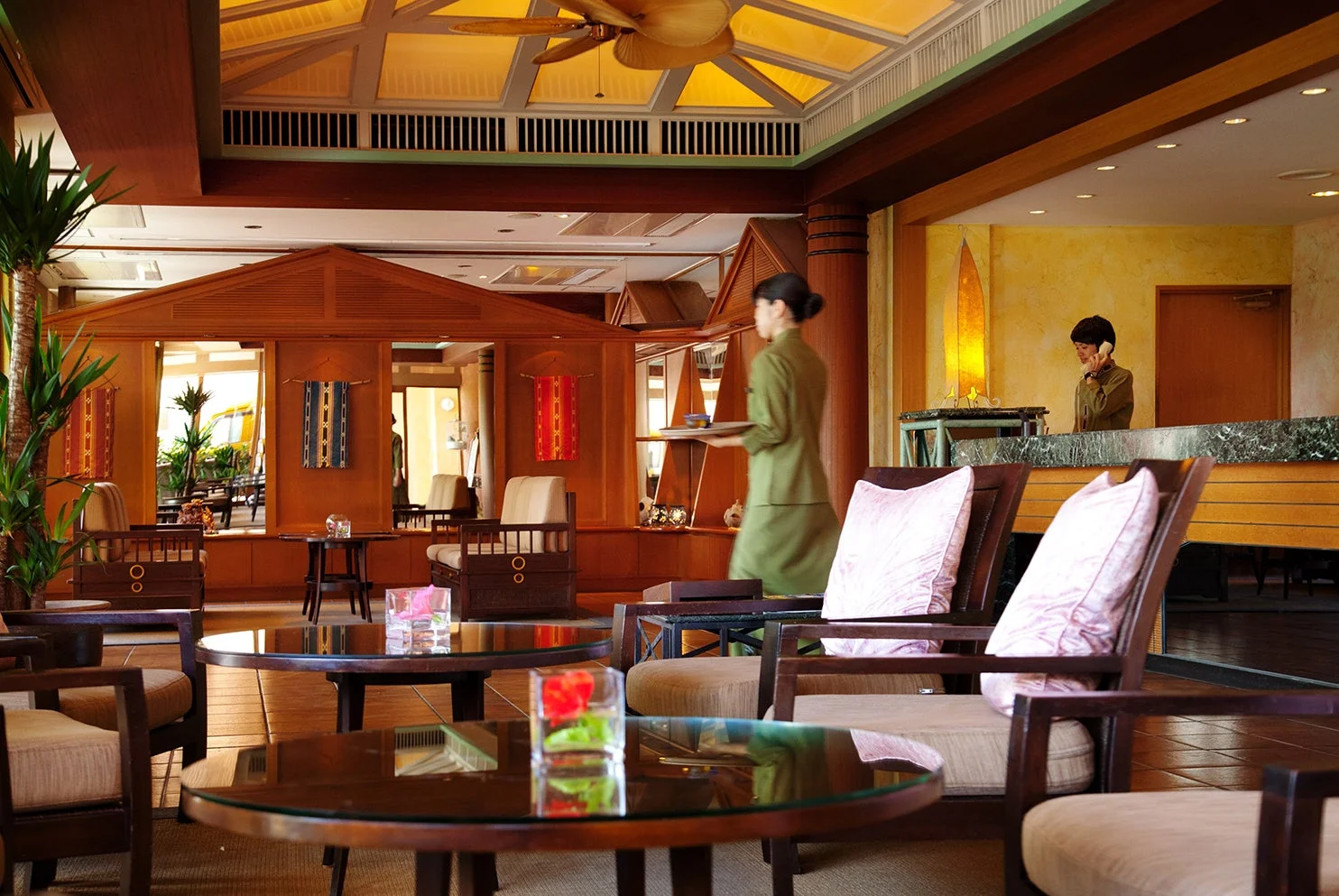 木製の家具と天井扇風機が特徴的なリゾートホテルのロビー