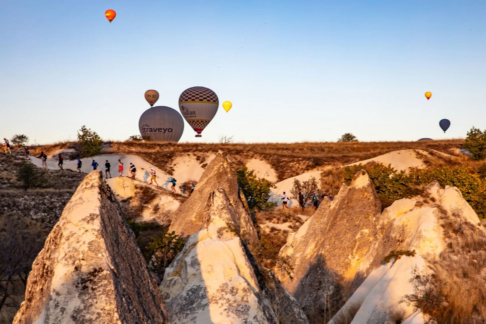 カッパドキアの熱気球とハイキングする人々