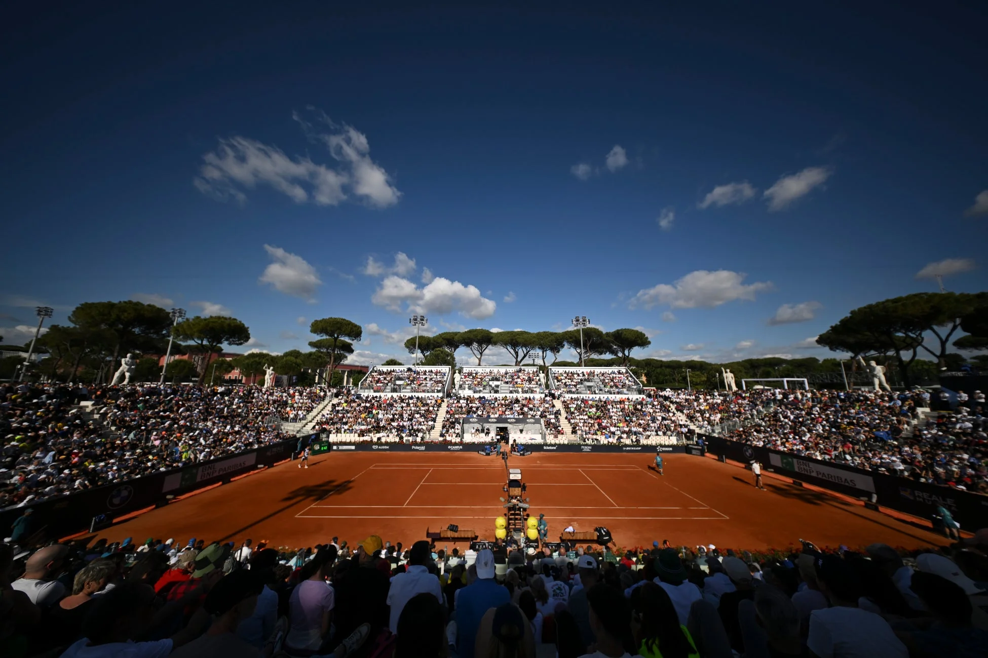 クレーコートでのテニス試合と観客席