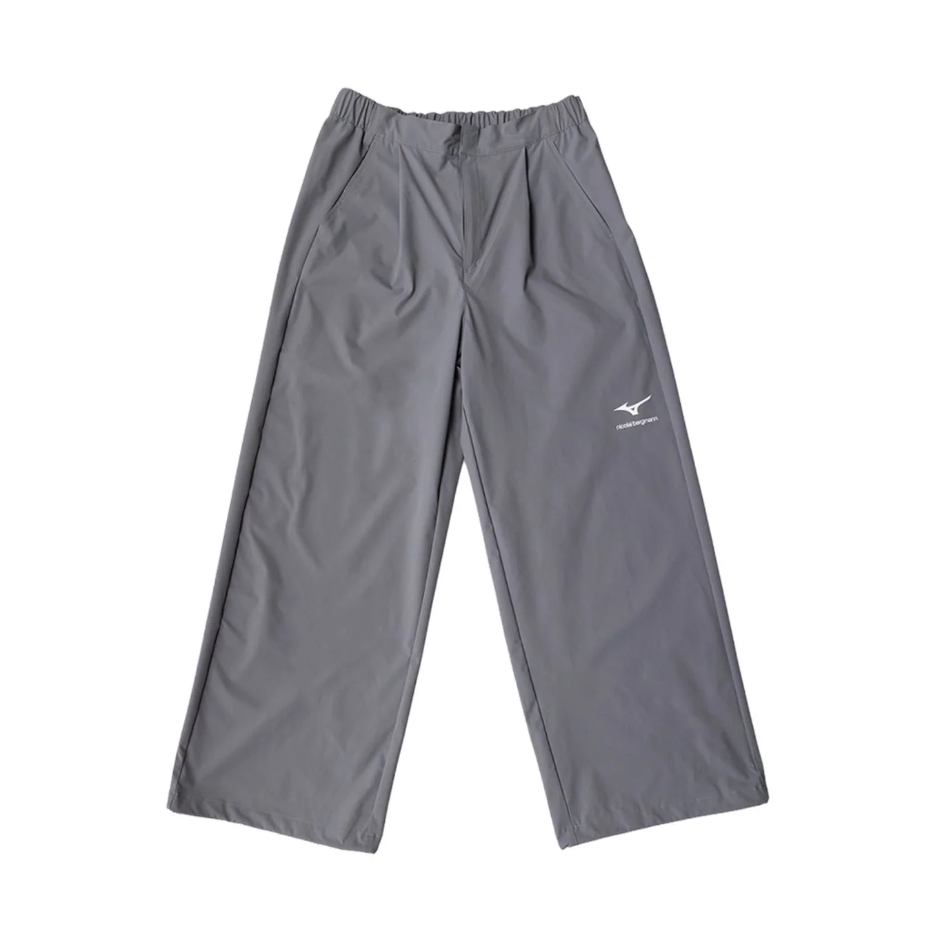 グレーのワイドシルエットのパンツで、ウエストはゴム仕様です。右足部分にはMizunoのロゴと「nicole bergmann」の文字がプリントされており、カジュアルな装いに適しています。