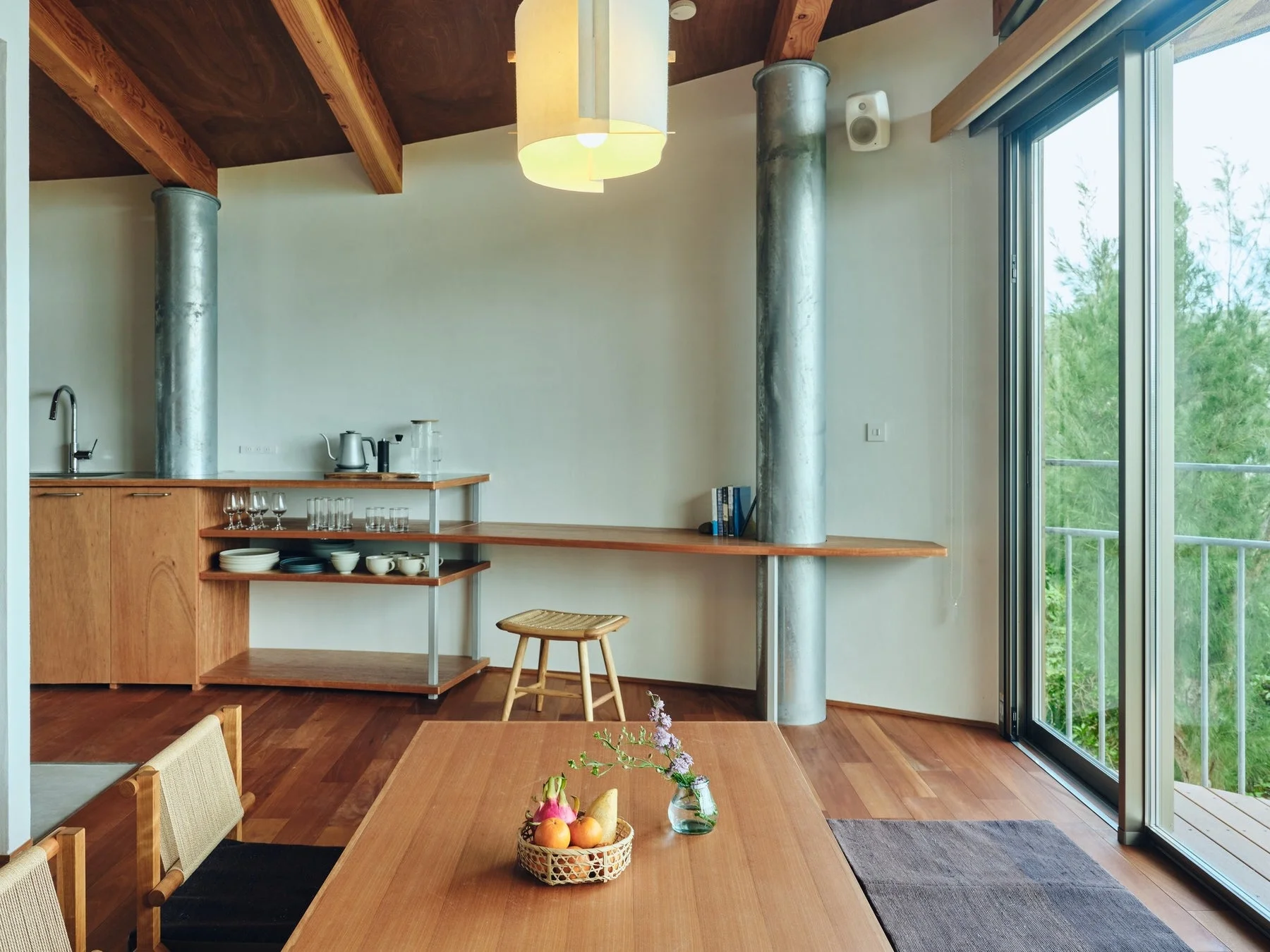 木製の床と天井が特徴の明るく開放的なダイニング兼キッチンスペース