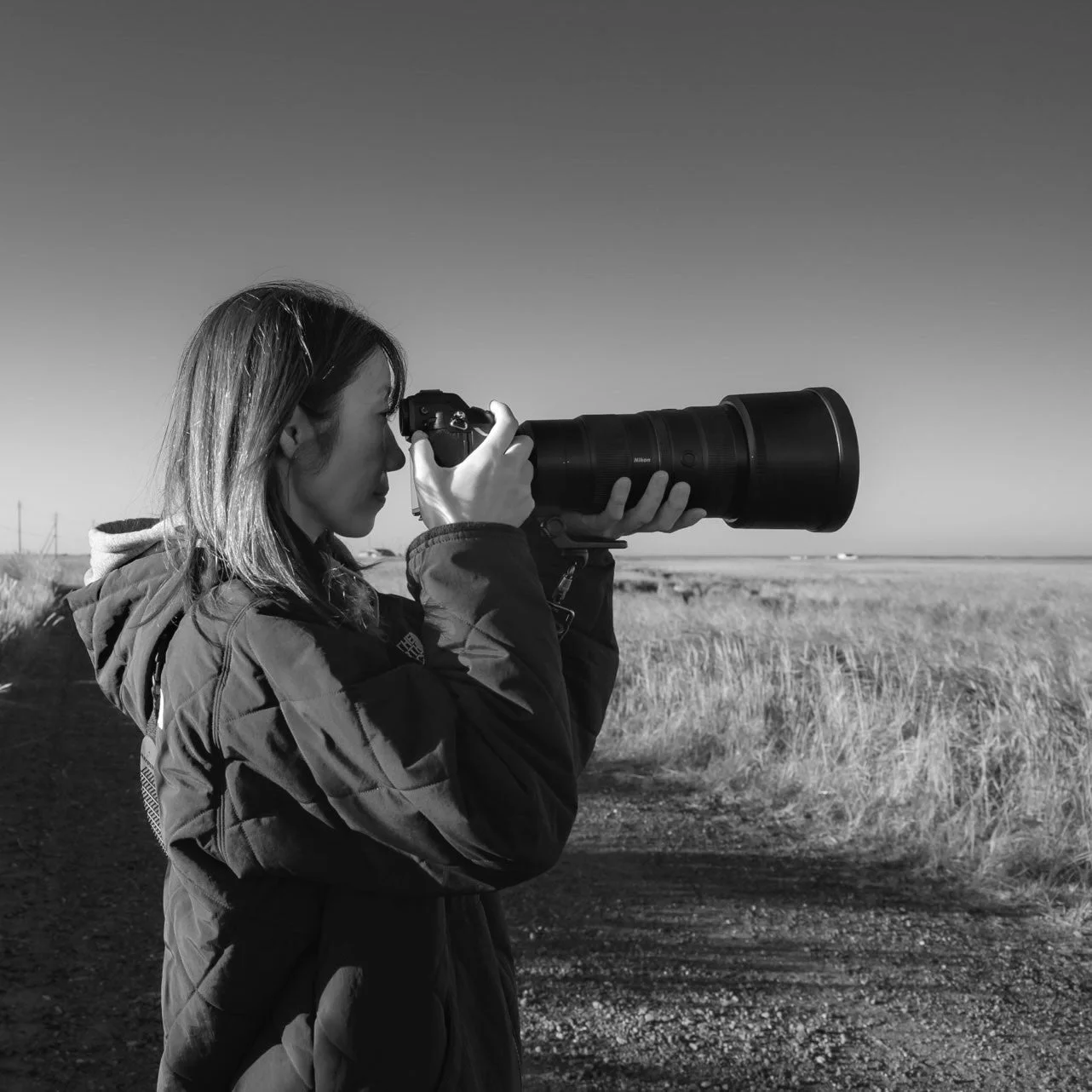 白黒、カメラを構える女性