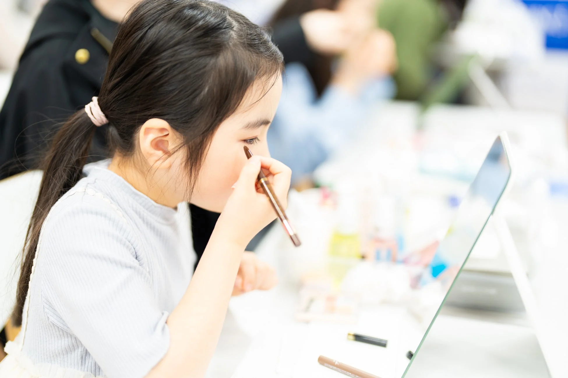 子どもが鏡を見ながらアイメイク