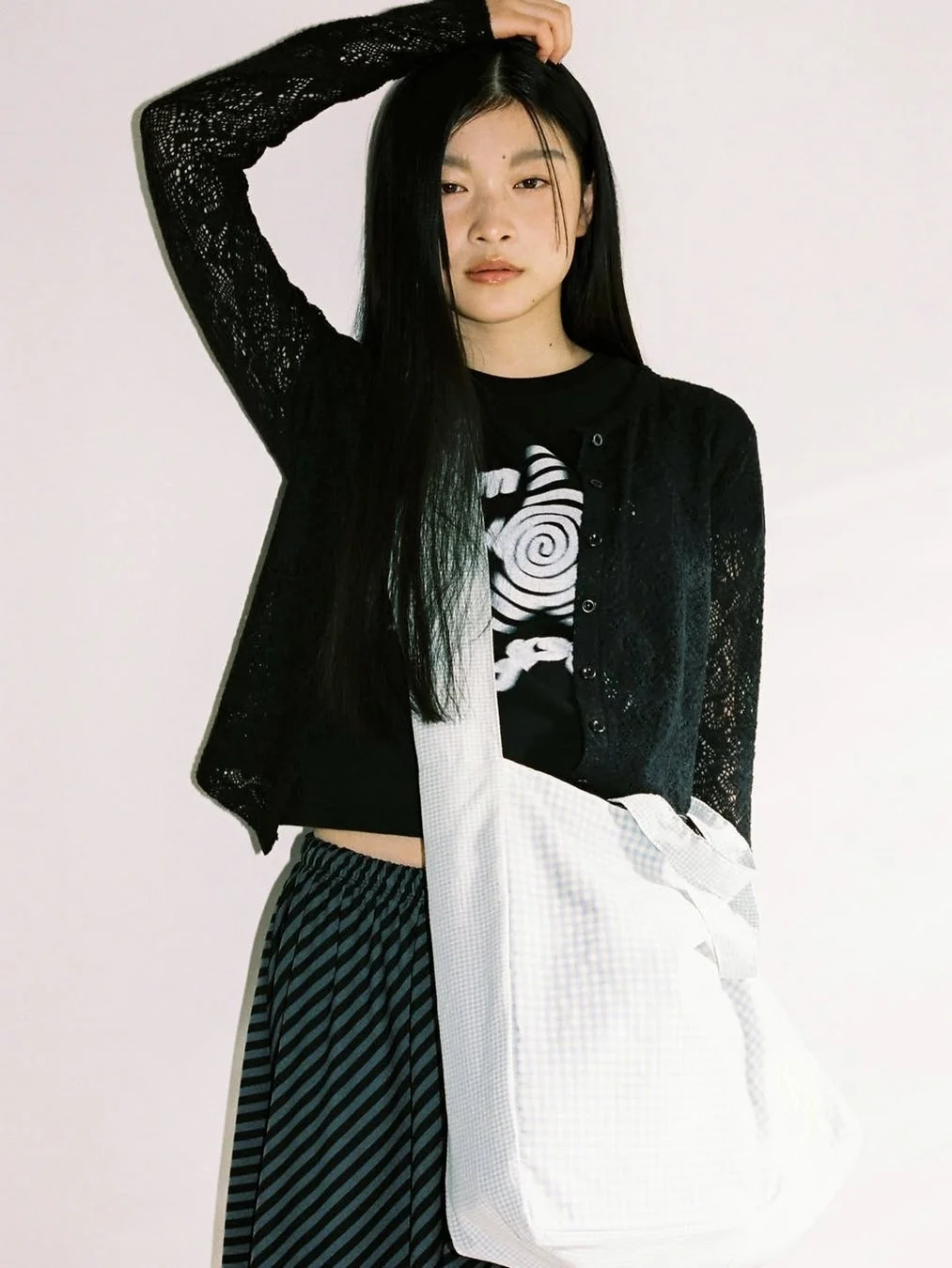 カーディガンとストライプスカートの女性