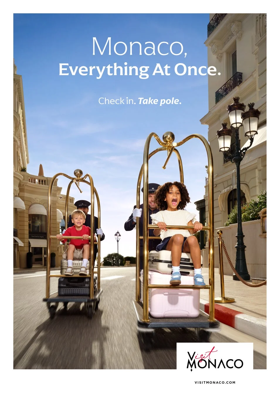 ベルボーイが子供たちを乗せた荷物カートを押す様子