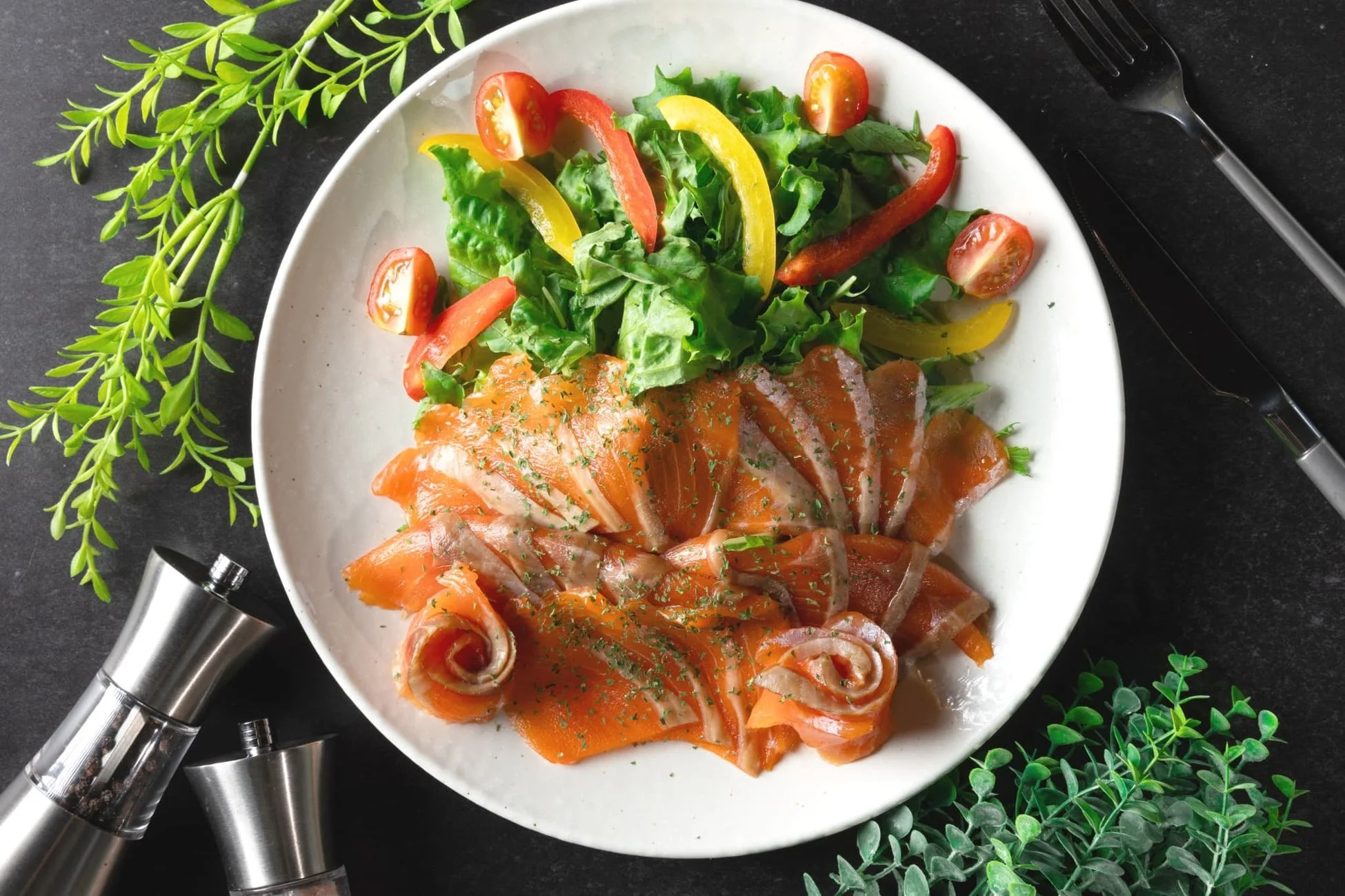 白い皿に盛り付けられたスモークサーモンのカルパッチョ