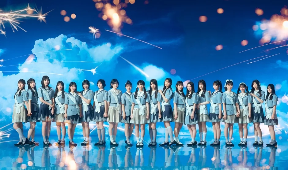 青空の下で整列する女性アイドルグループ