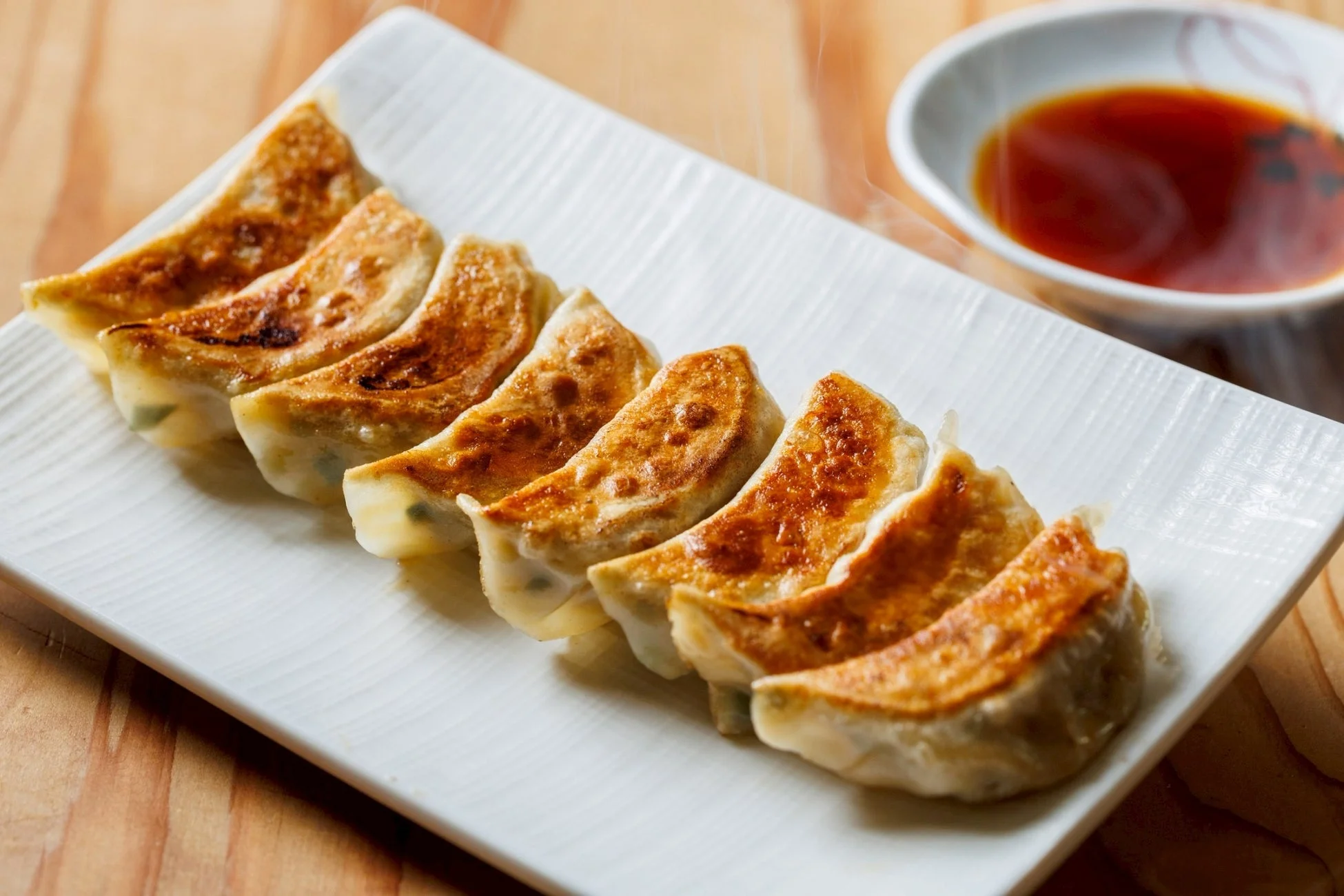 白い長皿にきれいに並べられた焼き餃子
