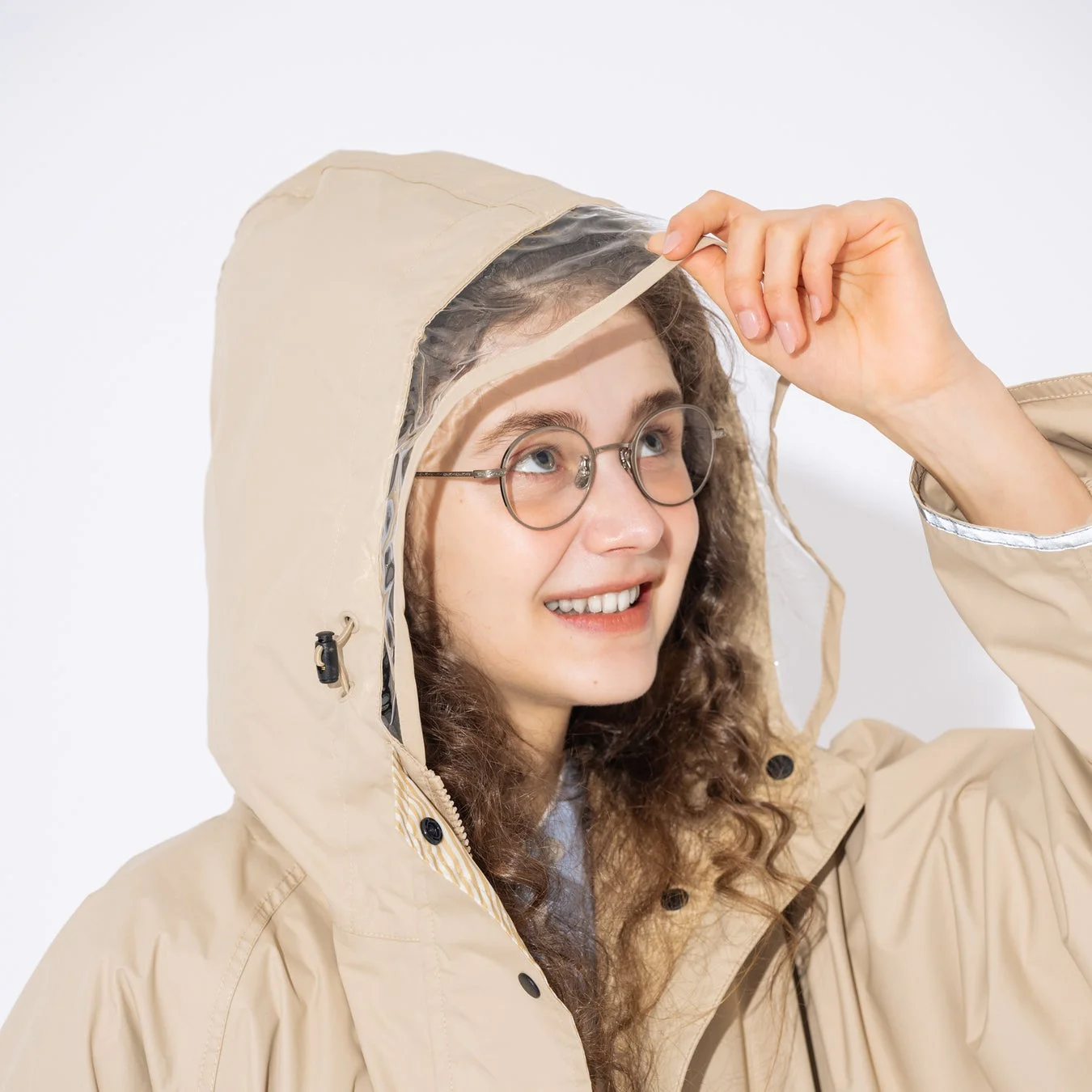 ベージュのレインコートを着た女性