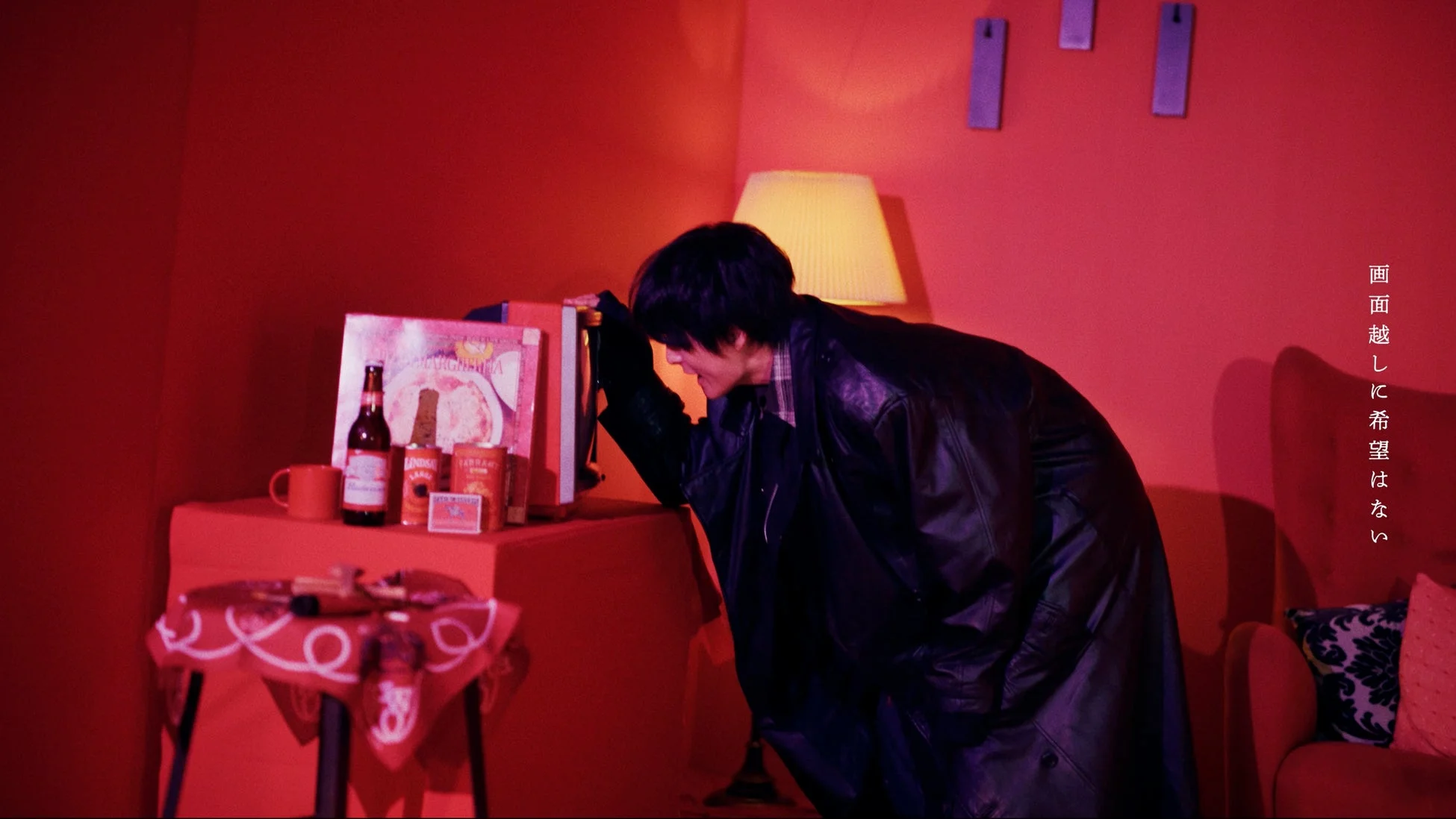 赤い部屋で物憂げな雰囲気の男性