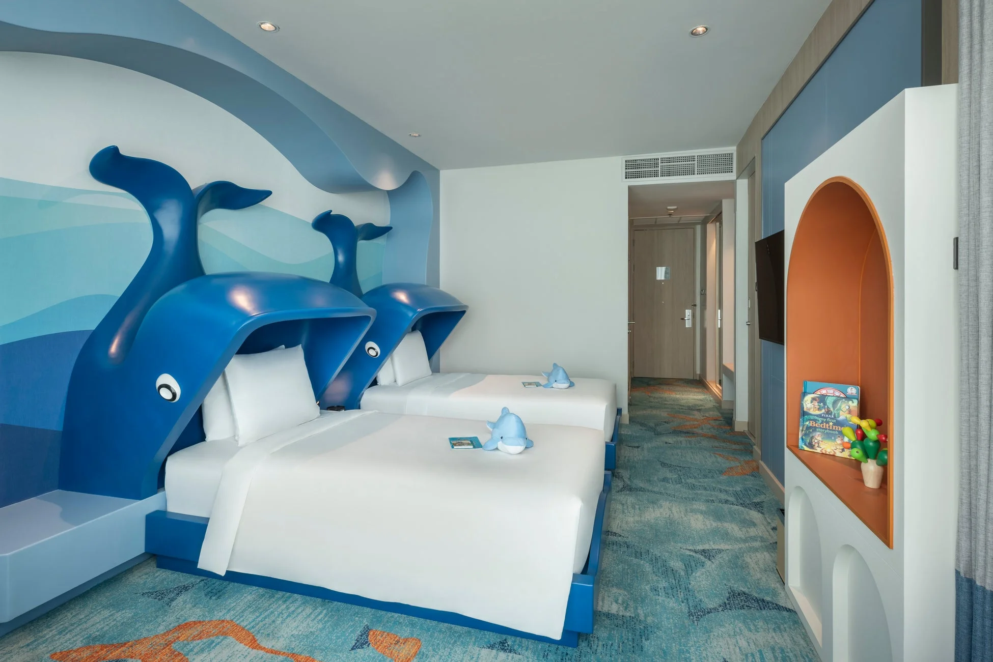 クジラの形をしたベッドが特徴的な、海洋テーマの子供向けホテル客室