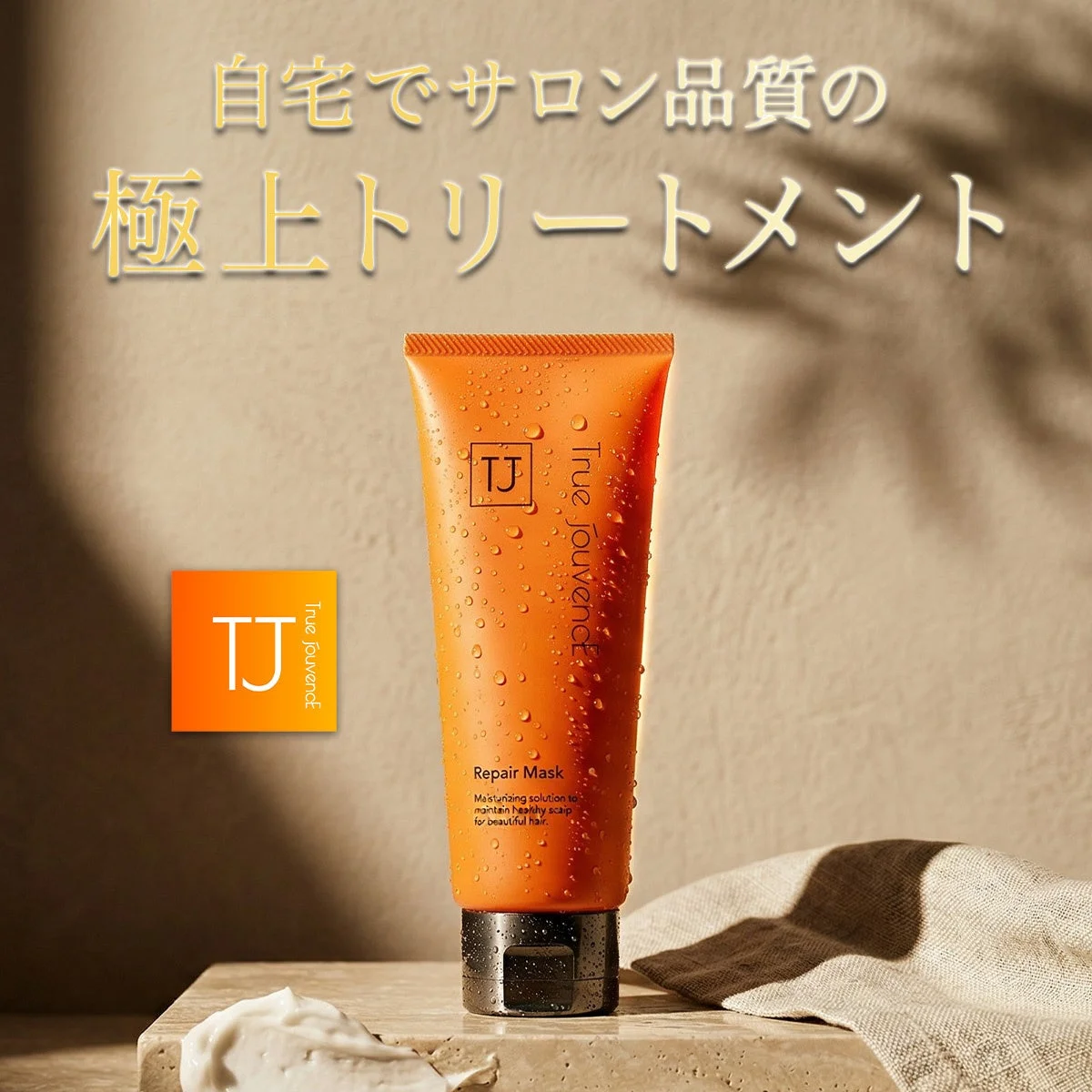 水滴がついたオレンジ色のヘアトリートメント「True Jouvence Repair Mask」が写っており、「自宅でサロン品質の極上トリートメント」という文字が添えられています。美しい髪と健康な頭皮を保つための保湿ソリューションです。
