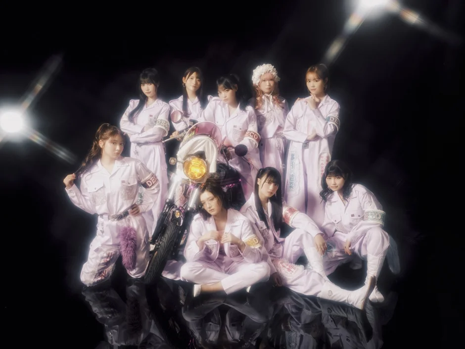 オートバイと共にポーズをとる女性アイドルグループ