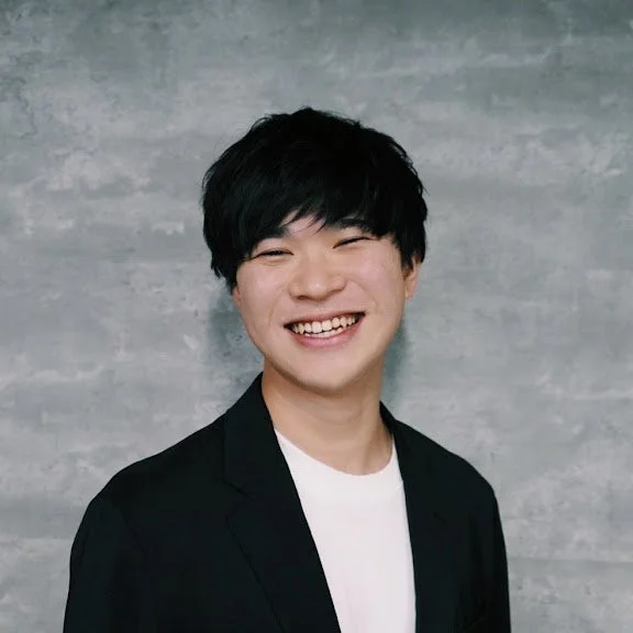 笑顔で正面を見つめる若い男性のポートレート