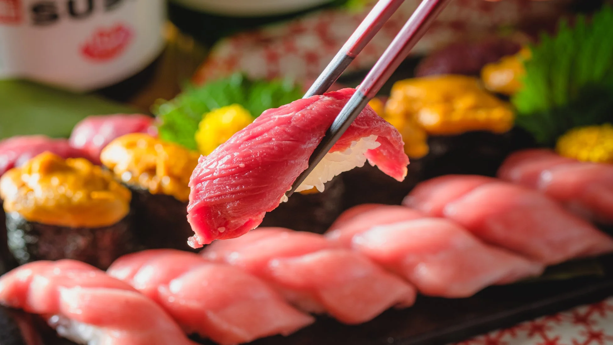 箸でつまみ上げられた新鮮なマグロの握り寿司