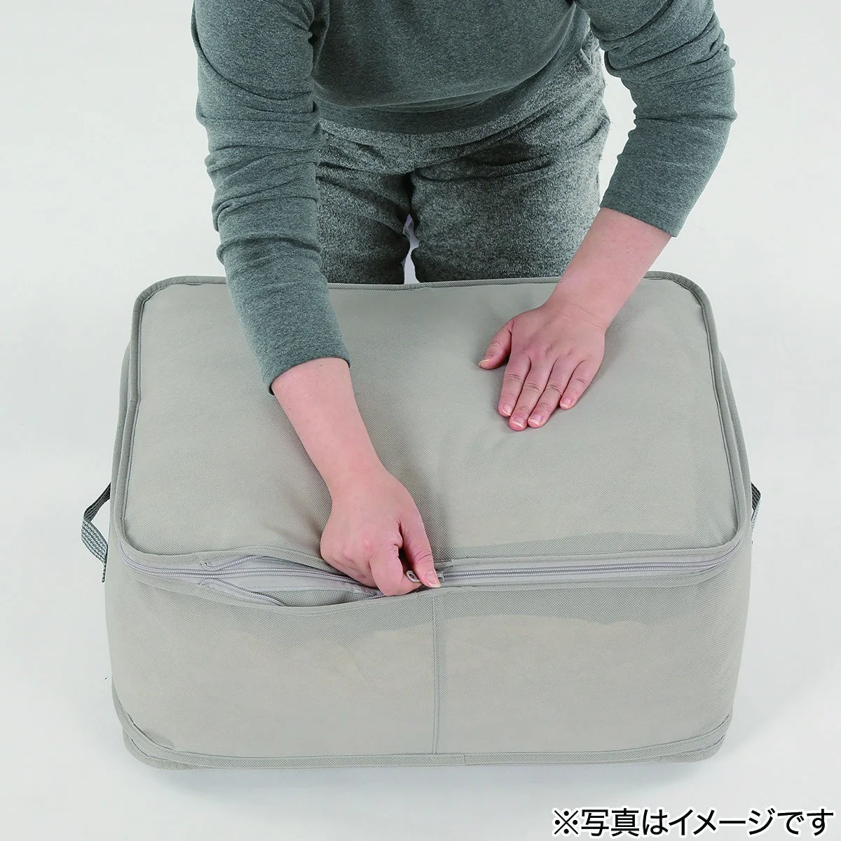 収納袋の側面ファスナーを閉める様子