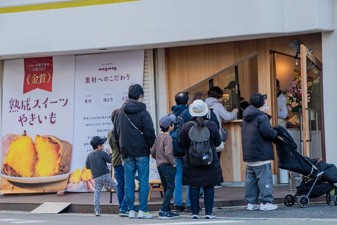 さつまいも専門店「mogmog」の店頭に、多くの人々が並んで焼き芋を買い求めている様子