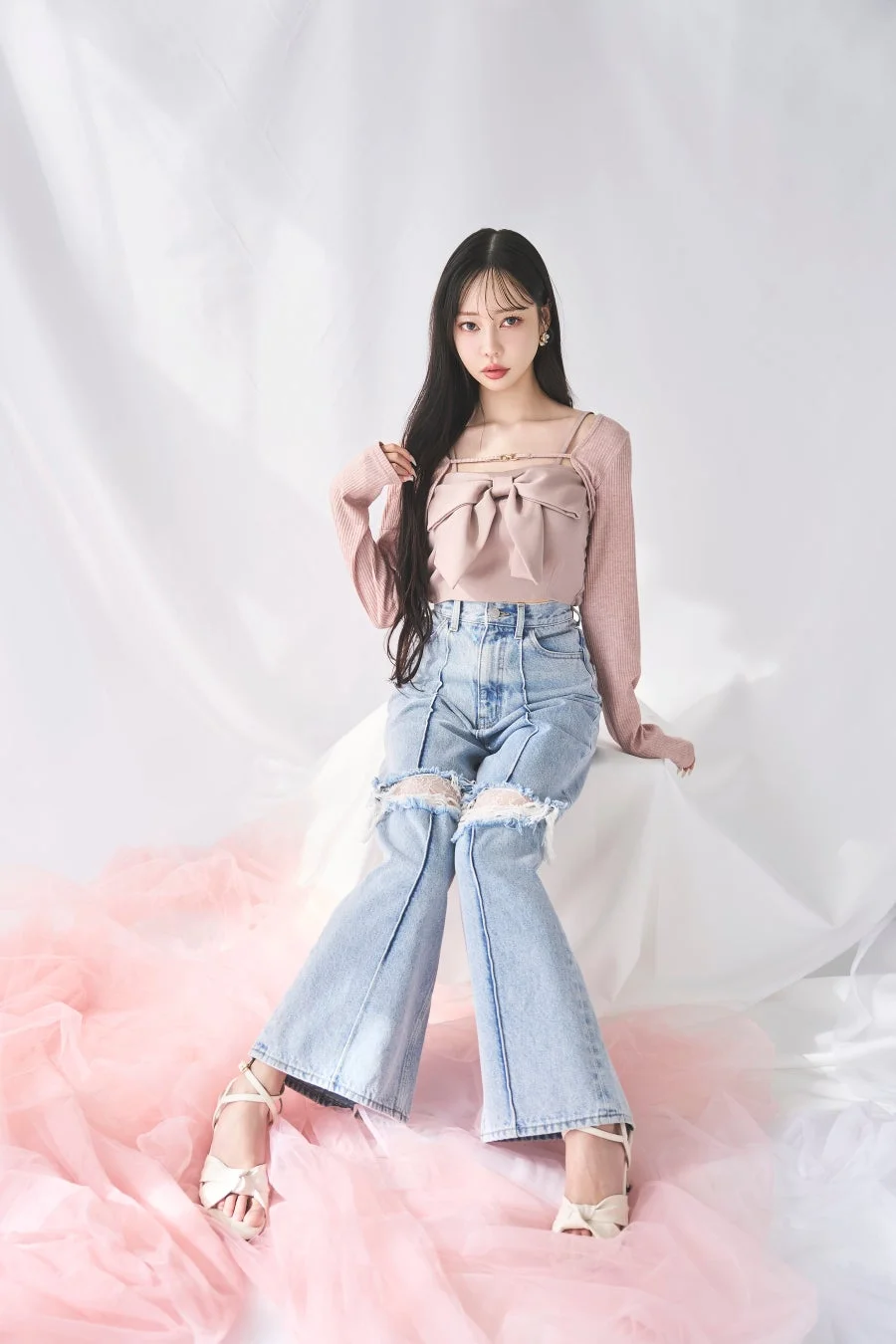 ピンクのリボントップスとダメージジーンズを着用した中村里砂さん