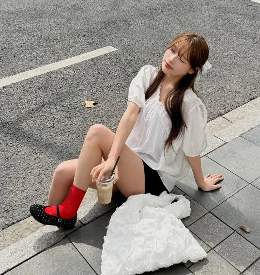 白いブラウスにショートパンツの女性