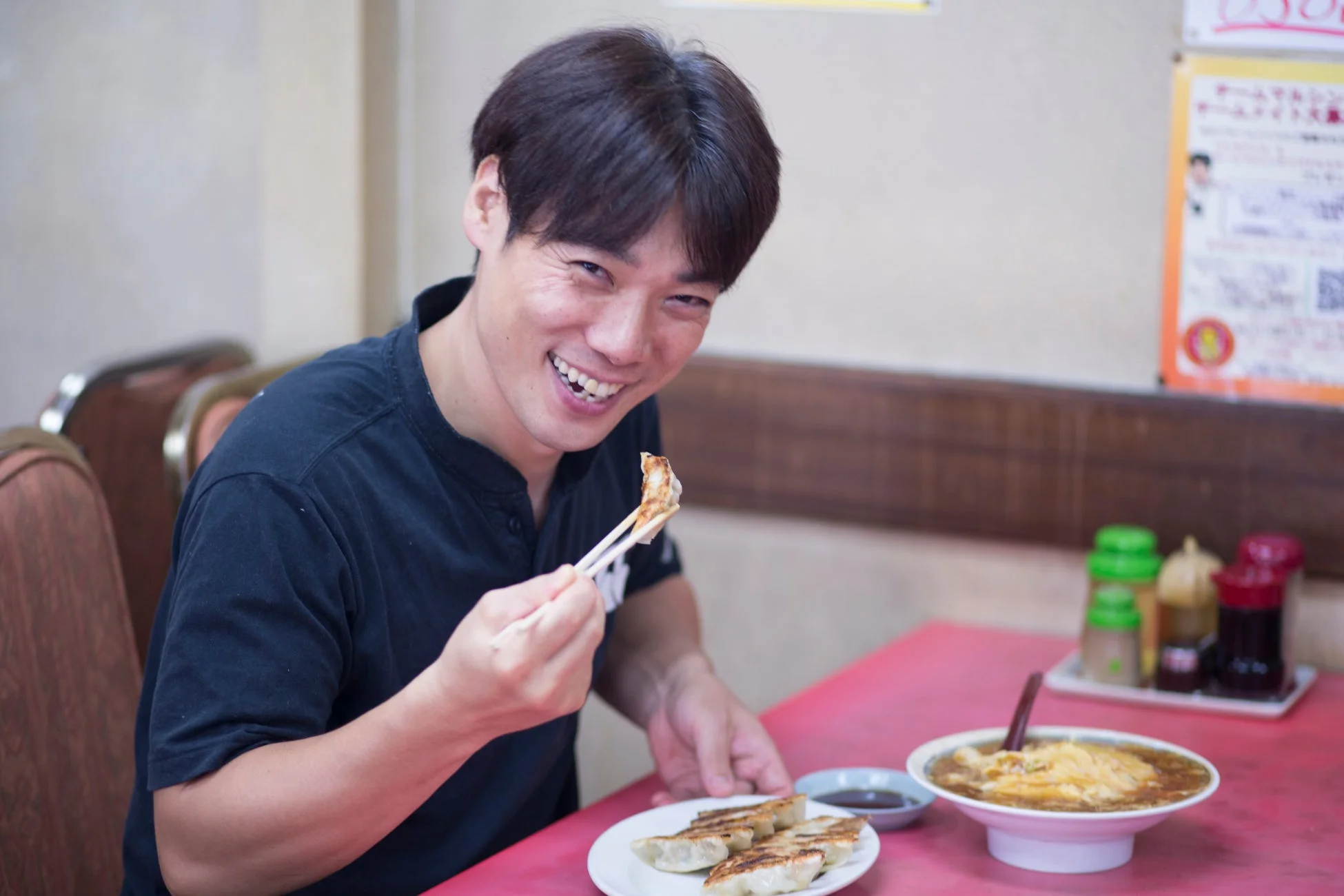 男性が餃子とラーメンを囲む