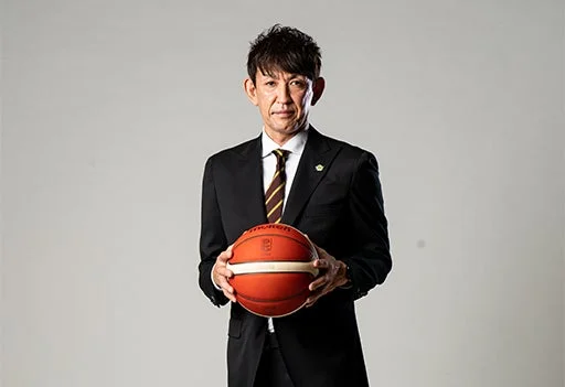 スーツ姿でバスケットボールを持つ折茂武彦氏