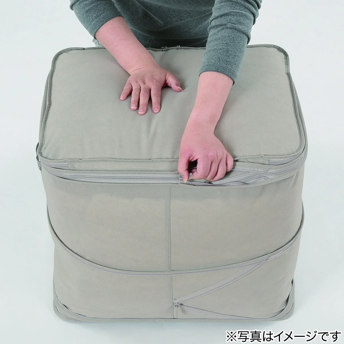 収納袋の上部ファスナーを閉める様子