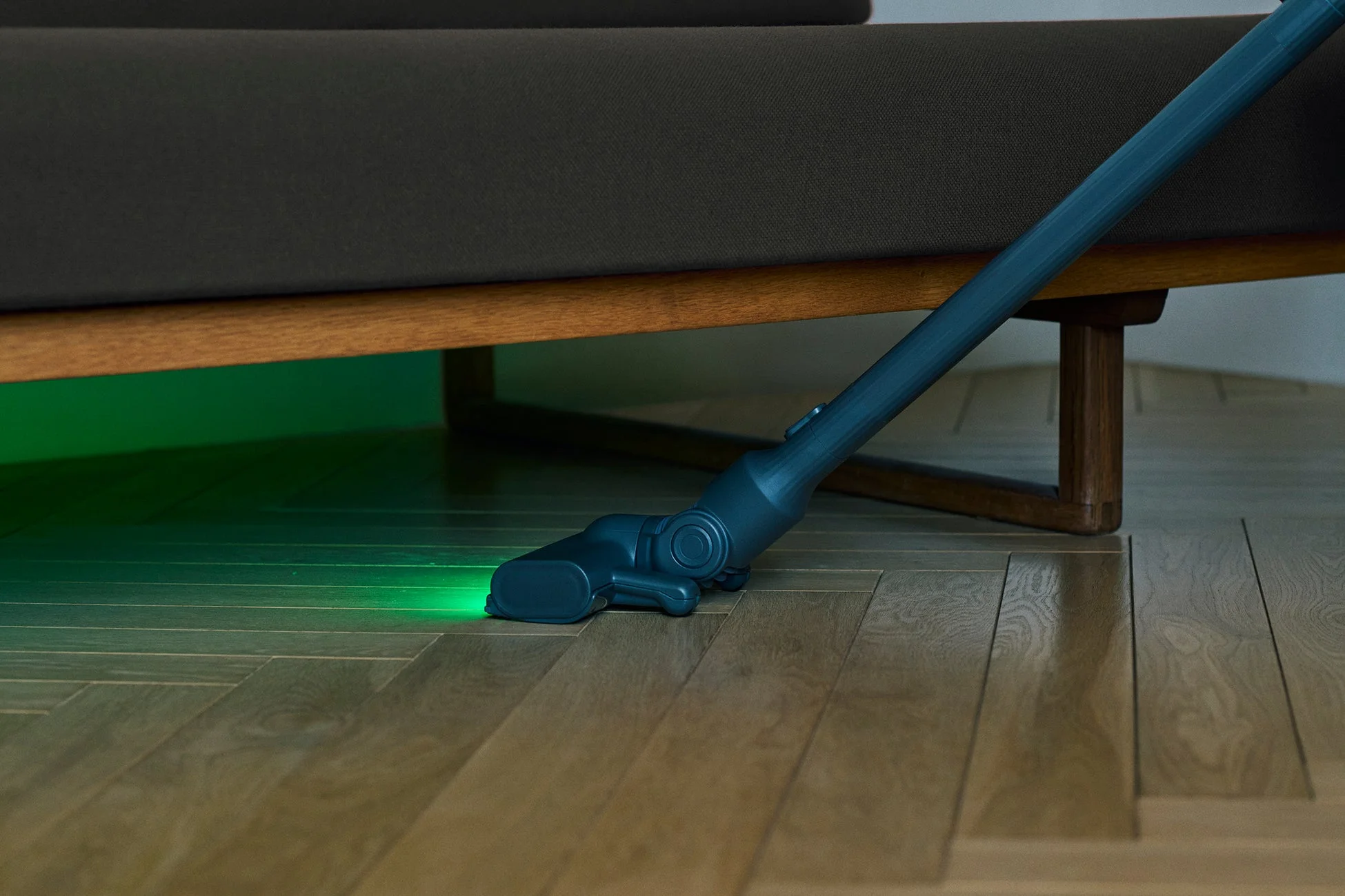 LEDライトでソファの下を掃除する様子