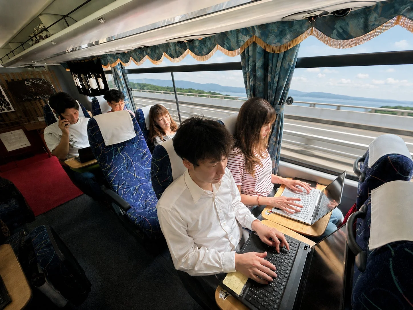 バス車内でノートパソコンで作業する人々