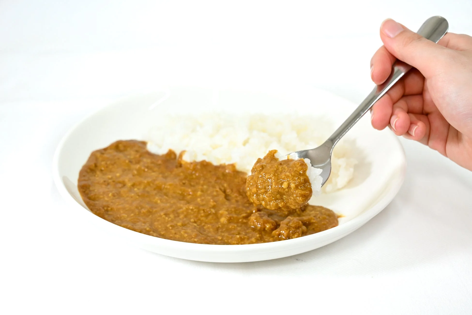 カレーライスをスプーンで掬う