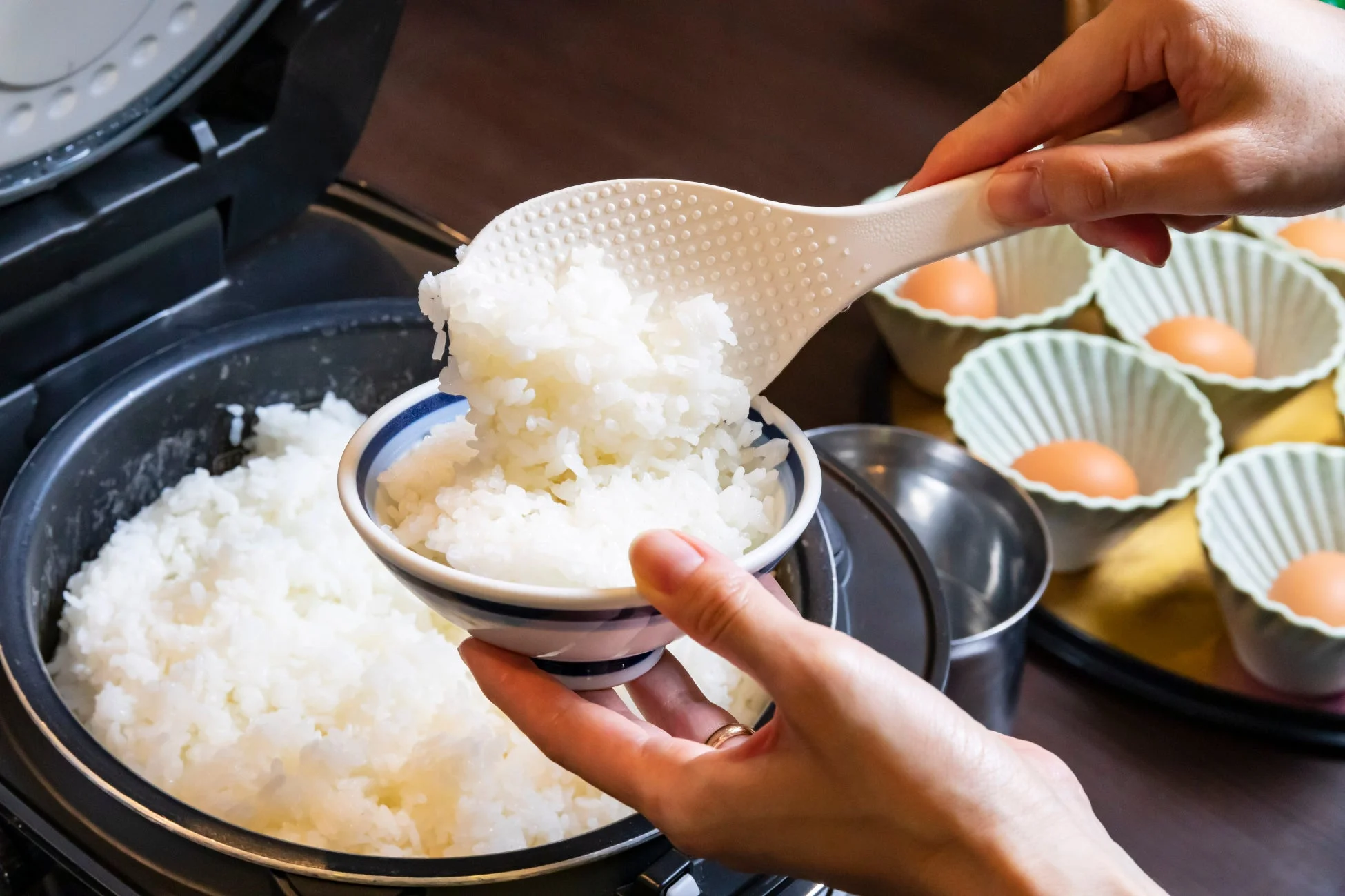 炊飯器からご飯をよそる様子