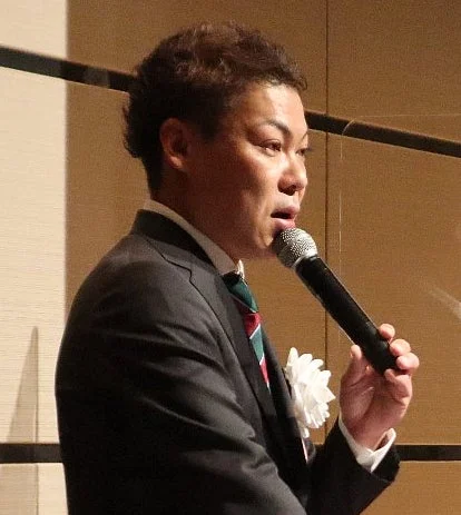 マイクを持って話す男性の様子