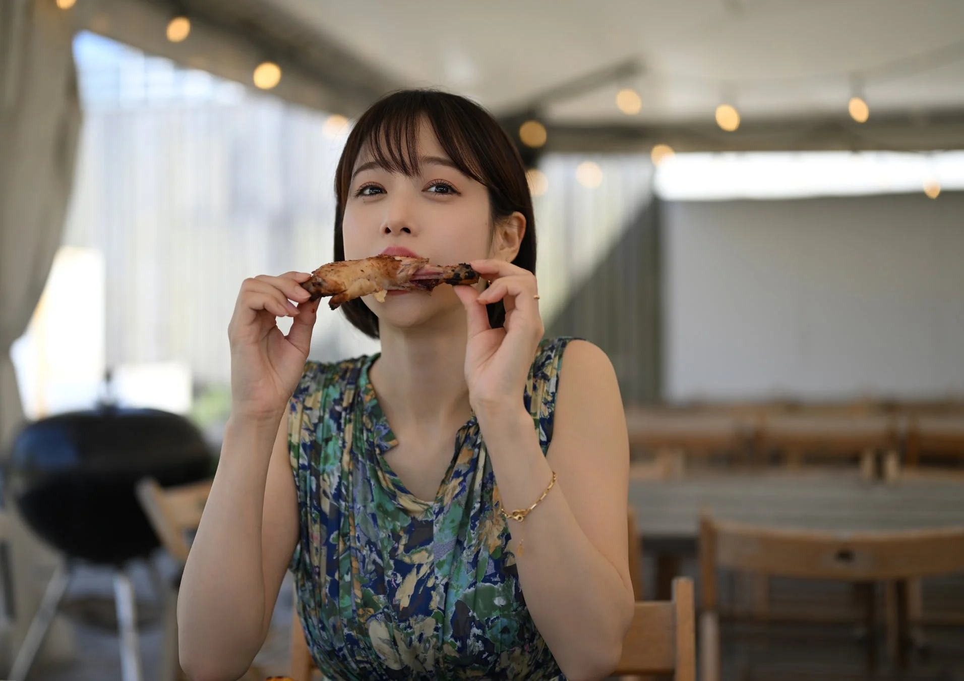 屋外でバーベキューの肉を食べる鷲見玲奈さん