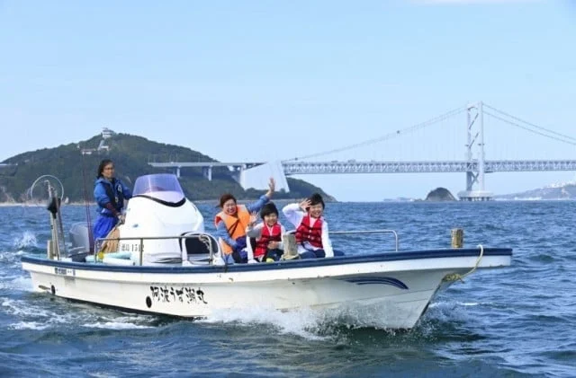 晴れた日に、家族連れが小型ボートに乗って海を楽しんでいる様子