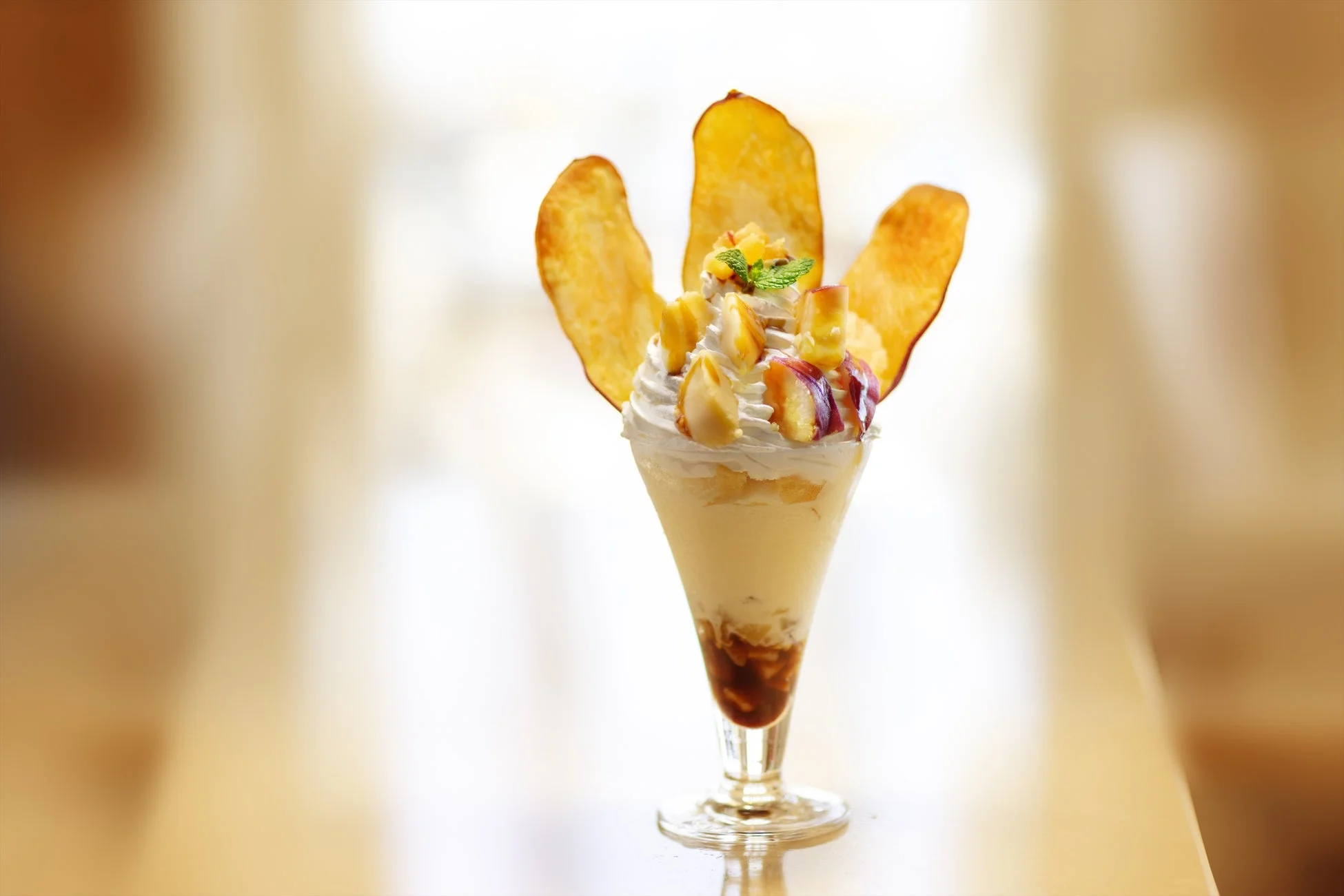 ホイップクリームとさつまいもチップスで飾られたパフェ