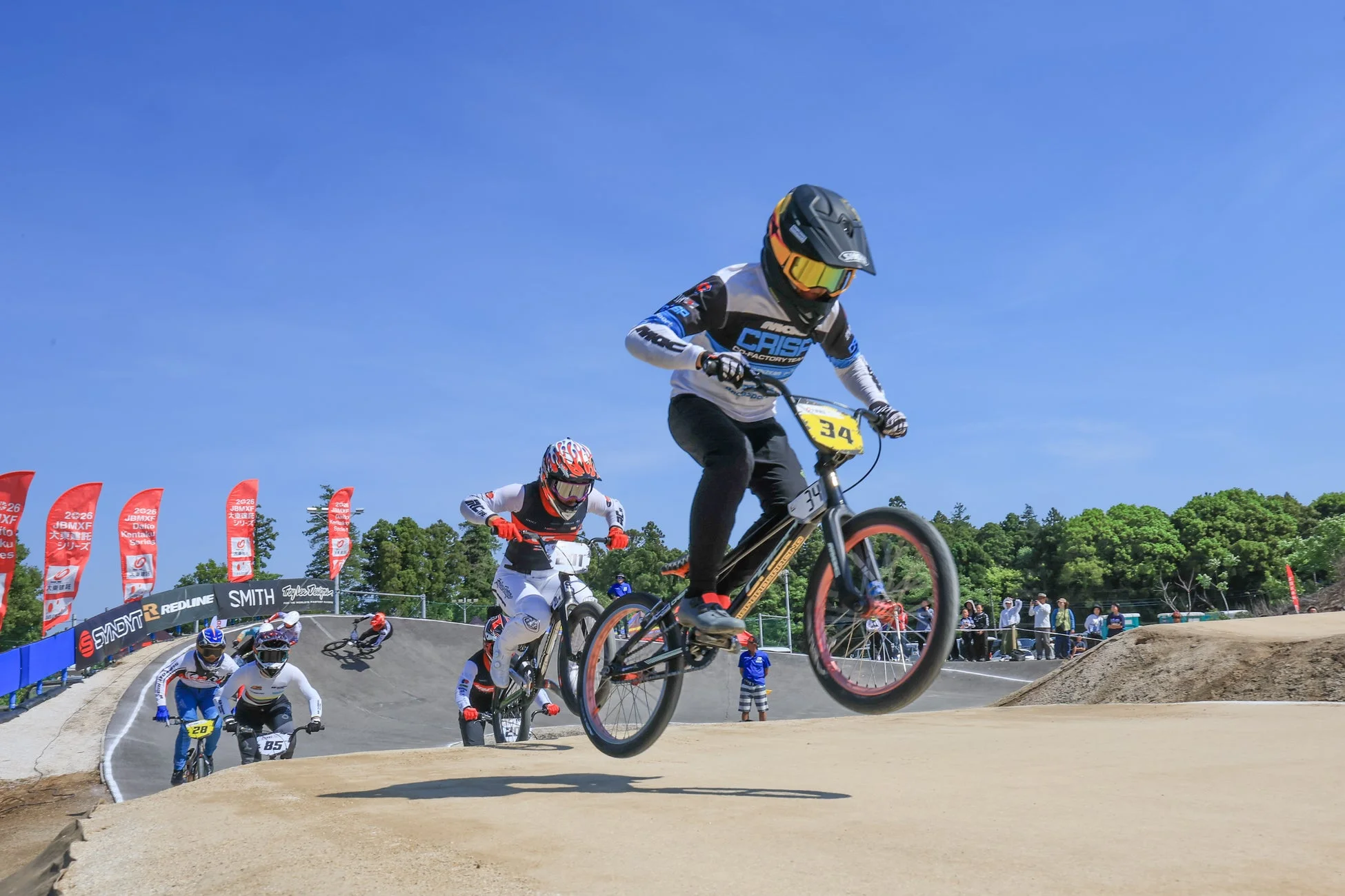 BMXレースで選手たちがダートトラックを疾走している