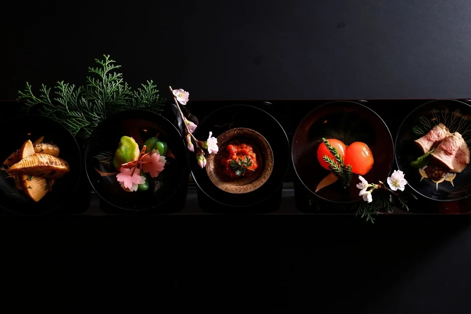 黒い漆器に盛り付けられた色とりどりの会席料理