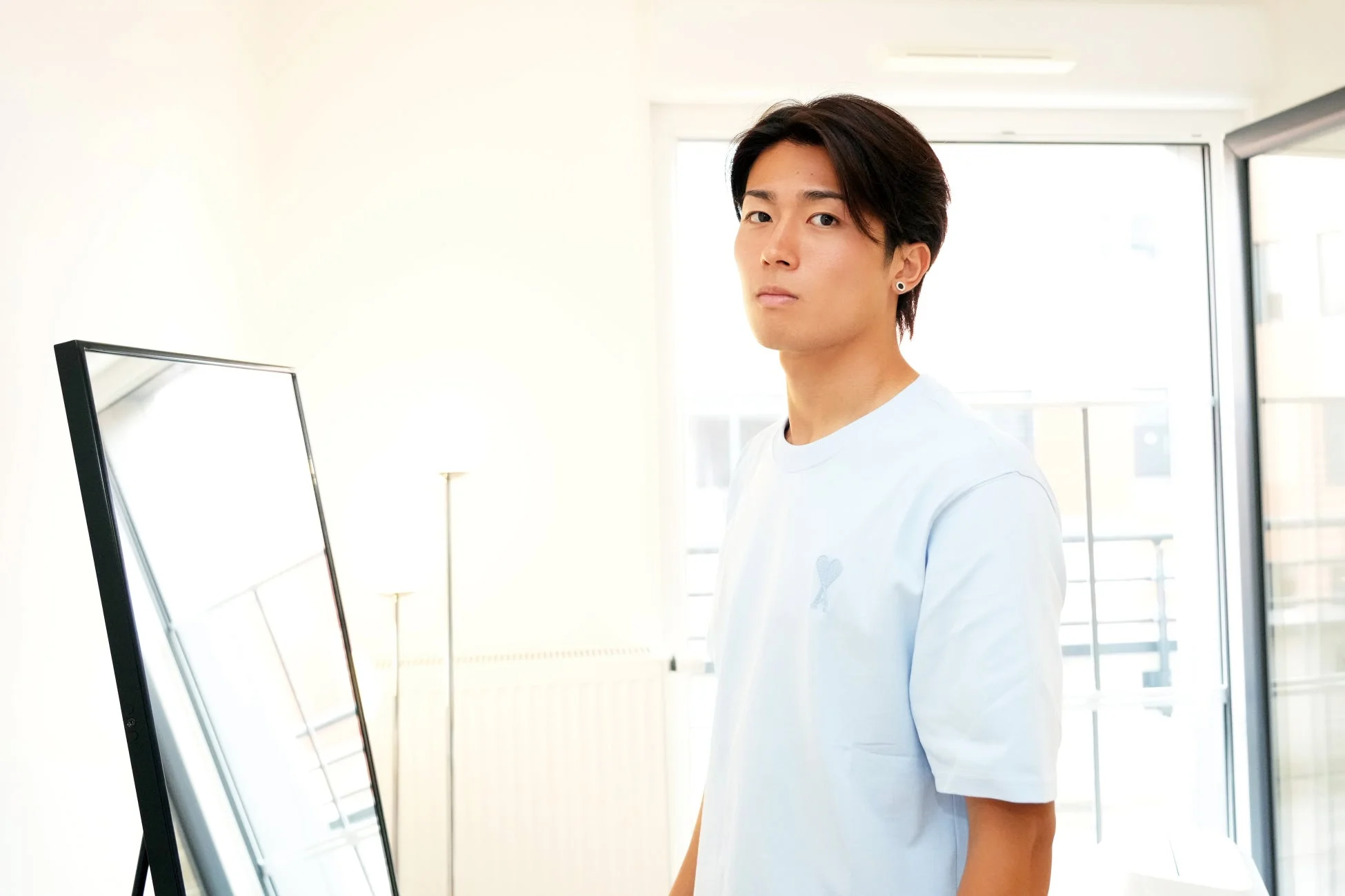 水色のTシャツを着てカメラを見つめる中村敬斗選手